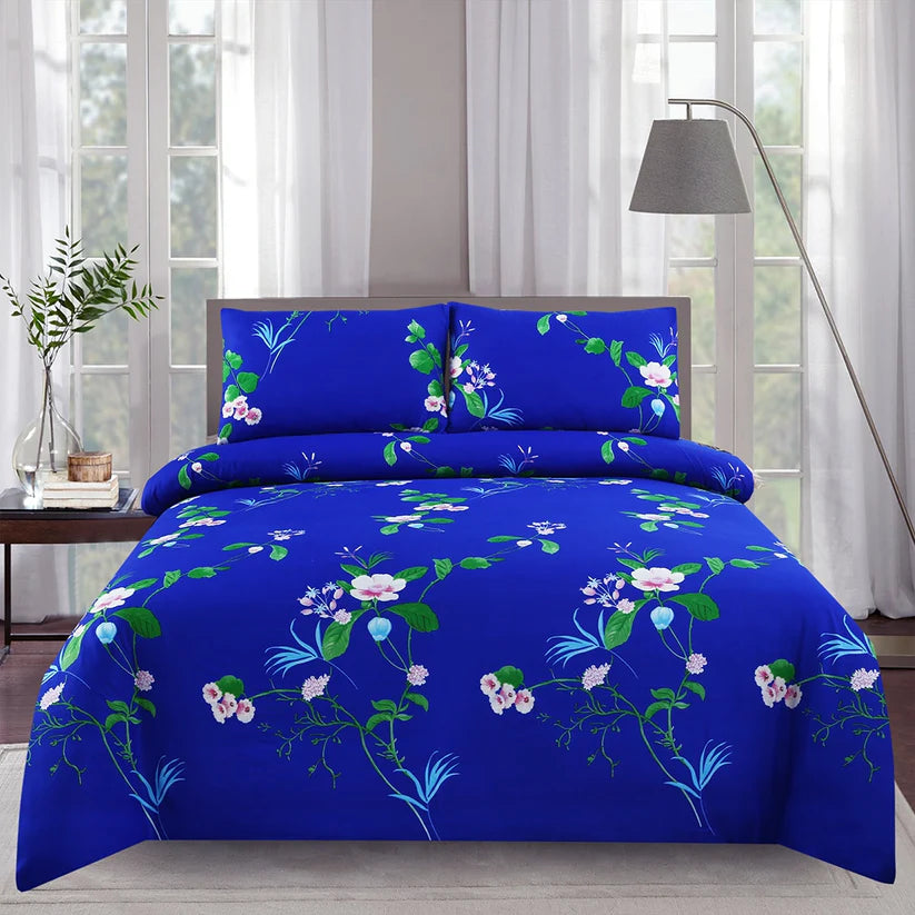 Blue floral bedding set on a bed in a bright room with curtains and a lamp.