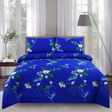 Blue floral bedding set on a bed in a bright room with curtains and a lamp.