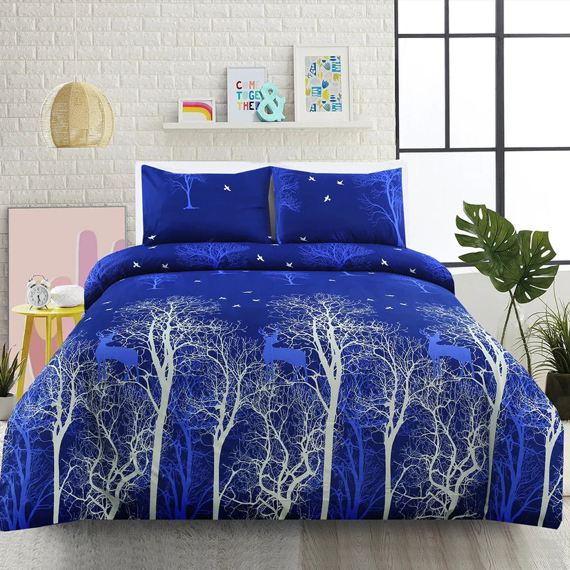 Blue and white tree-patterned comforter set on a bed with matching pillows, in a room setting.