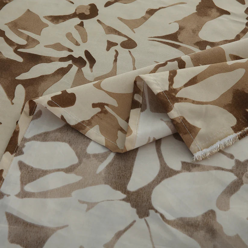 Floral patterned bedding set on a bed with a wooden headboard.