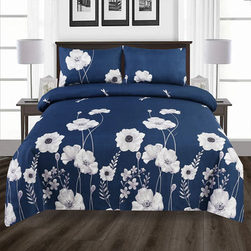 Navy blue floral bedding set on a bed in a room with white walls and framed pictures.