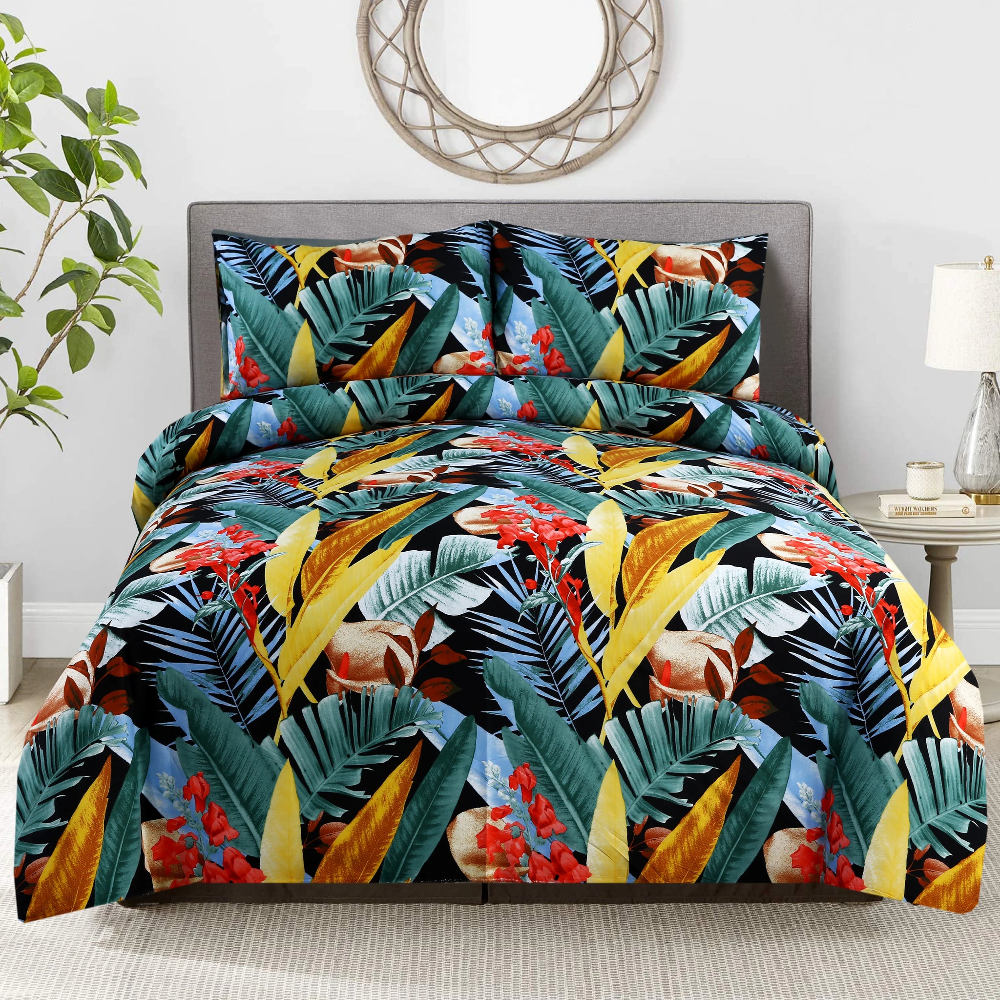 Tropical leaf patterned comforter set on a bed in a room with a plant and lamp.
