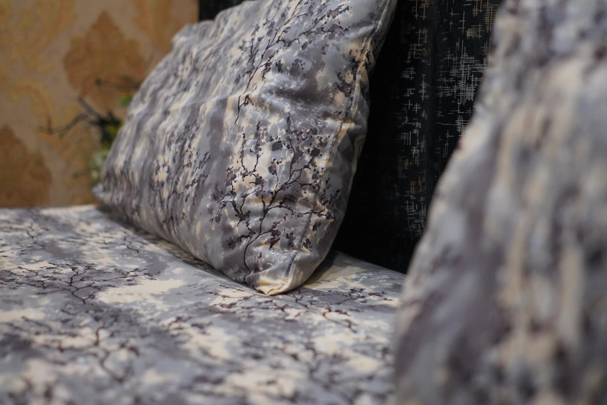 Gray textured pillow on a marble surface with a blurred background