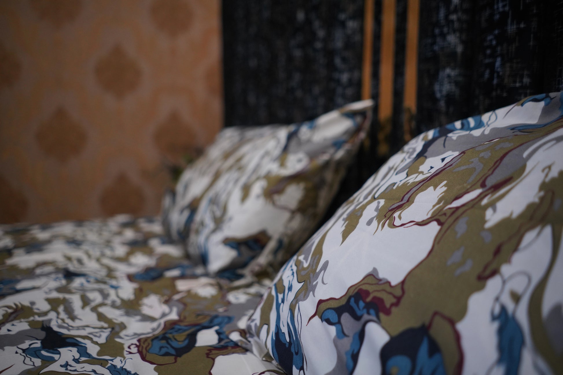 Patterned pillows on a bed with a blurred background