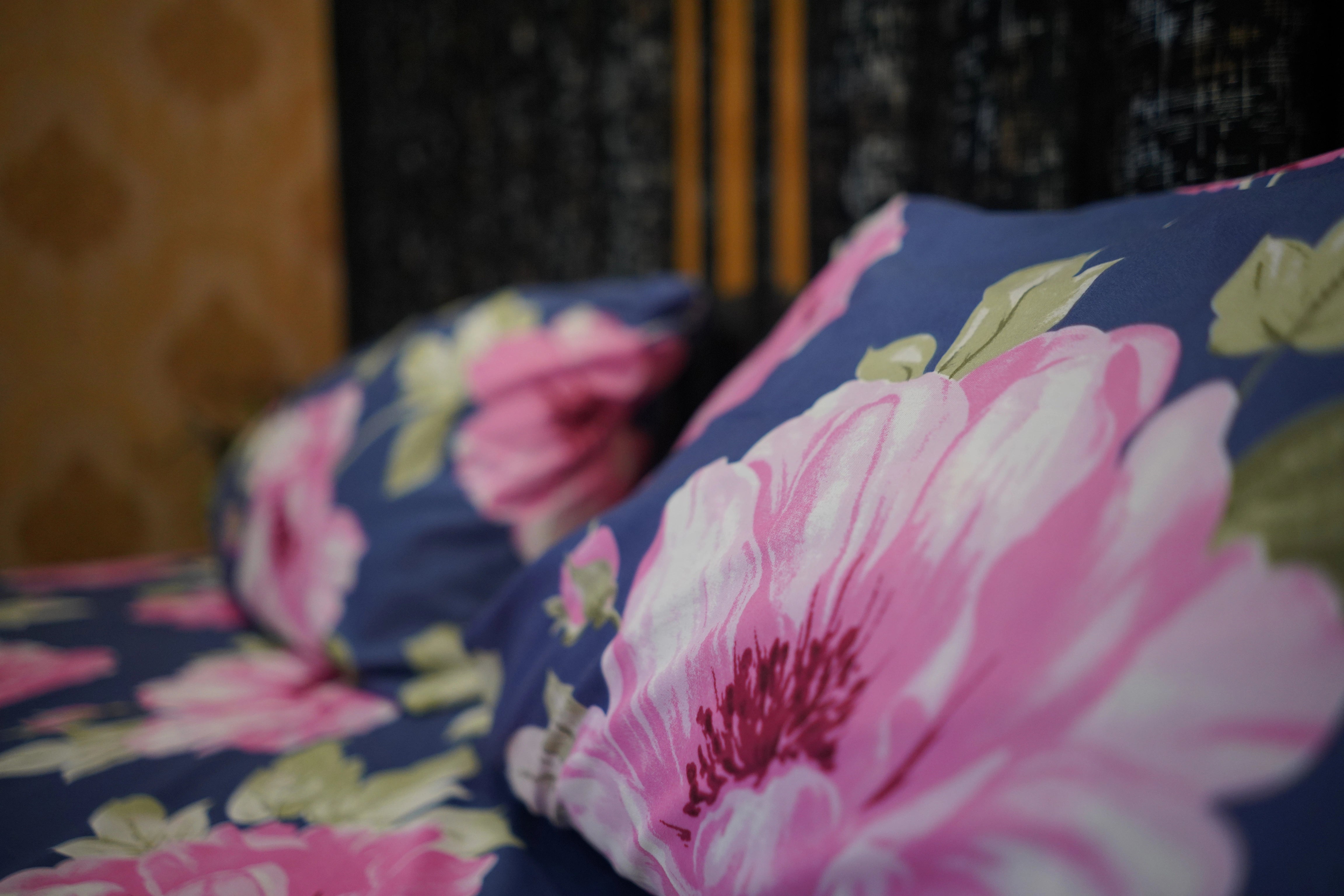 Floral-patterned cushions with pink flowers on a dark background
