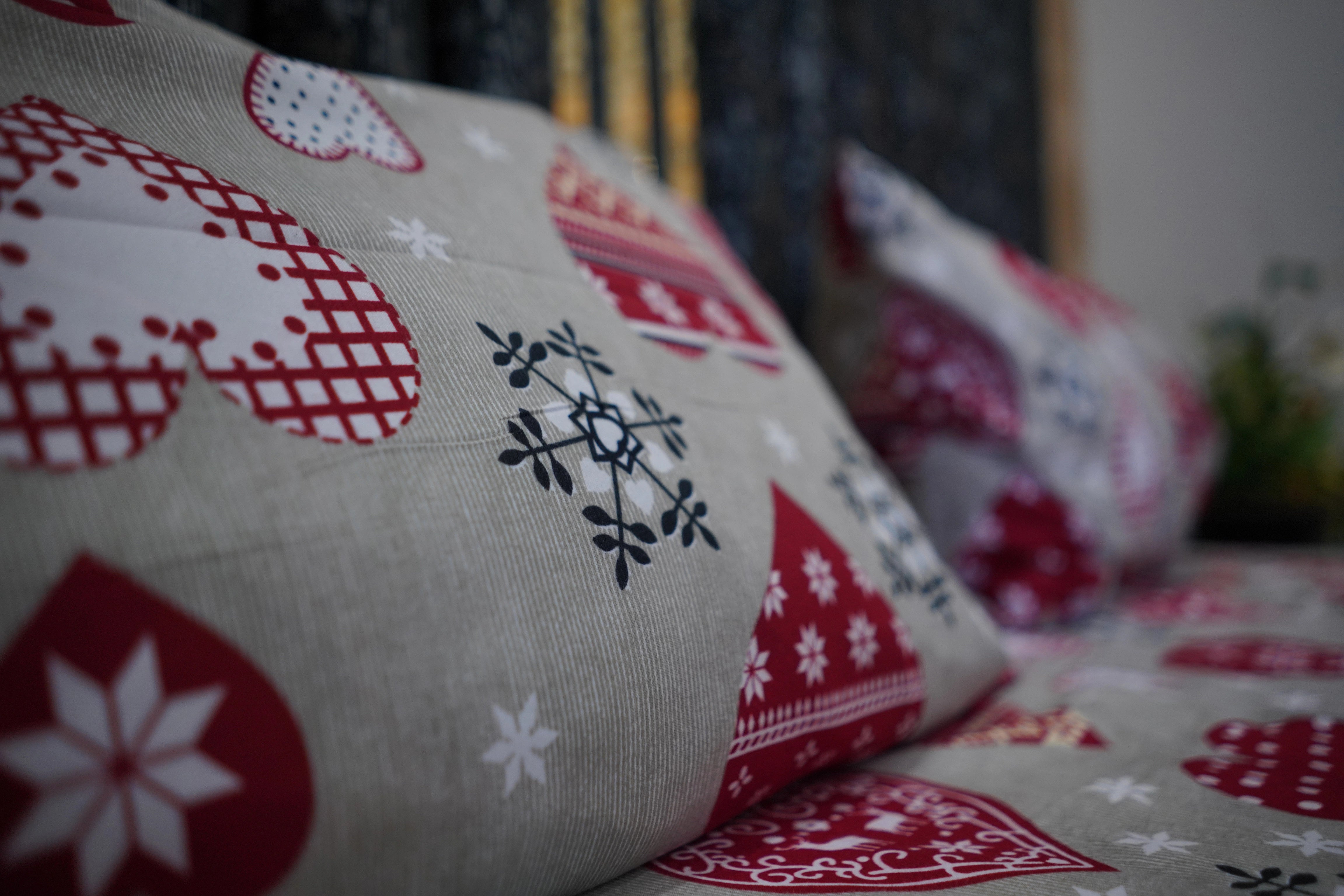 Decorative pillows with red and white patterns on a blurred background