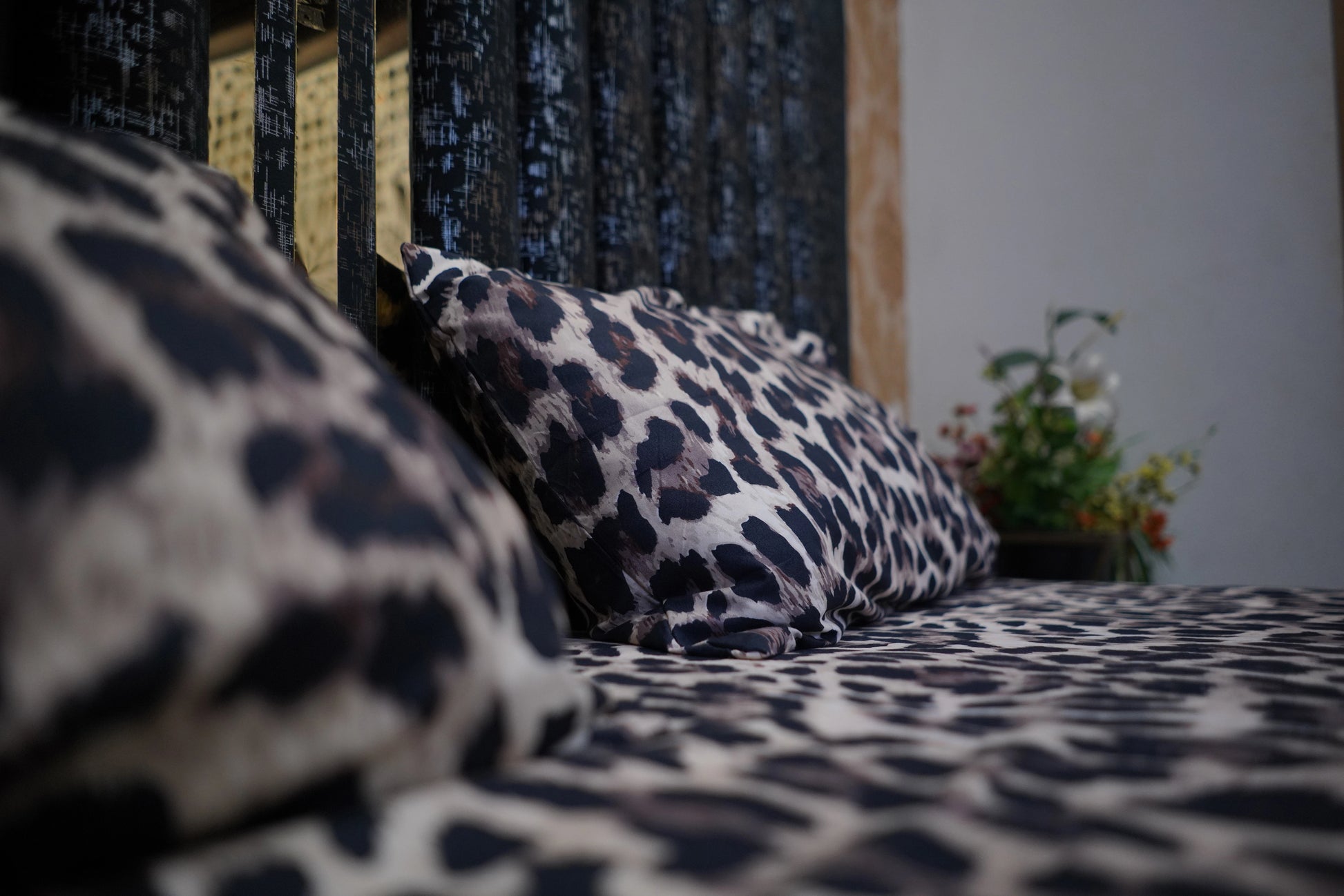 Leopard print bedding with a pillow on a bed in a room.