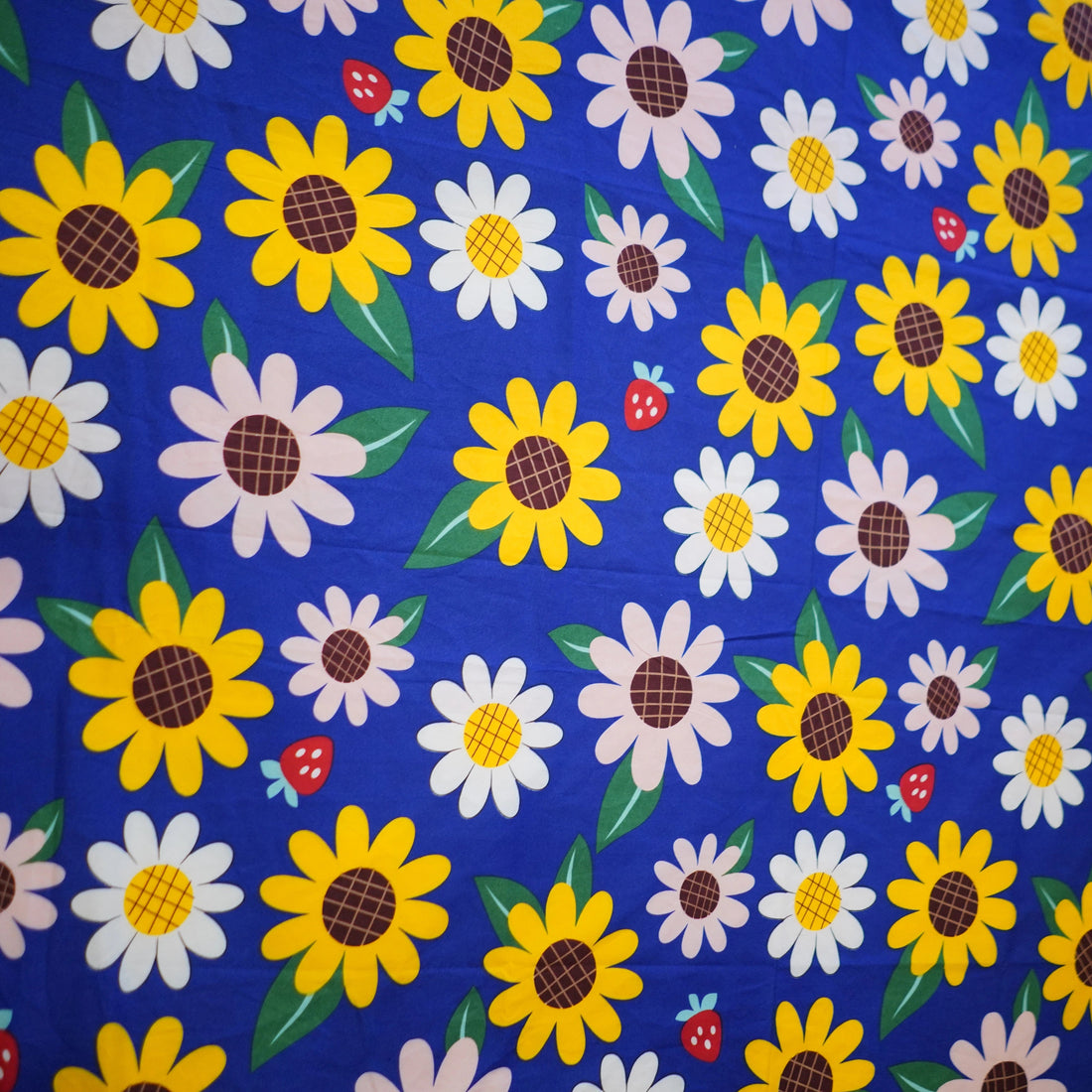 Floral patterned bedspread with matching pillows on a bed in a room setting.