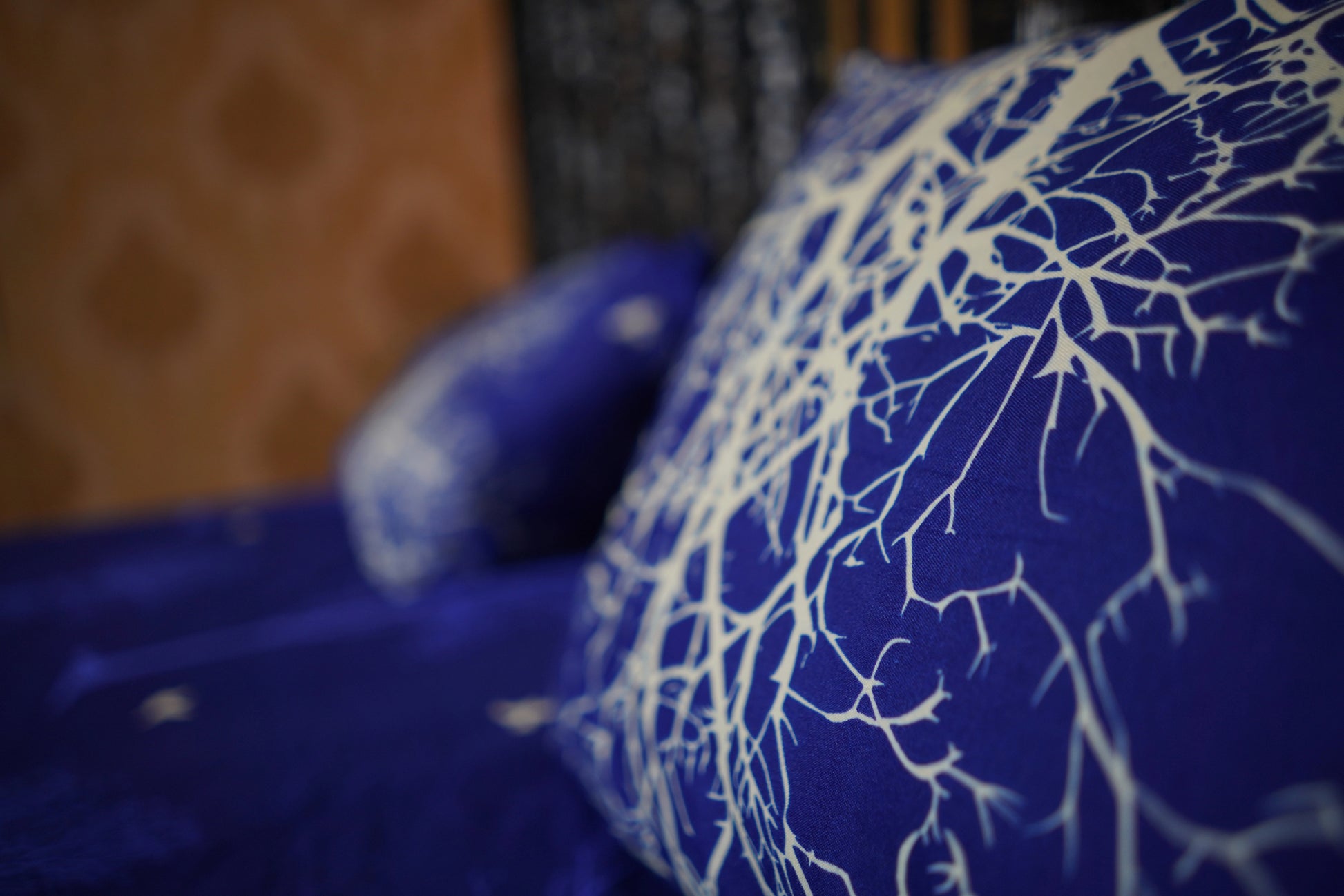 Blue fabric with white tree-like pattern, blurred background