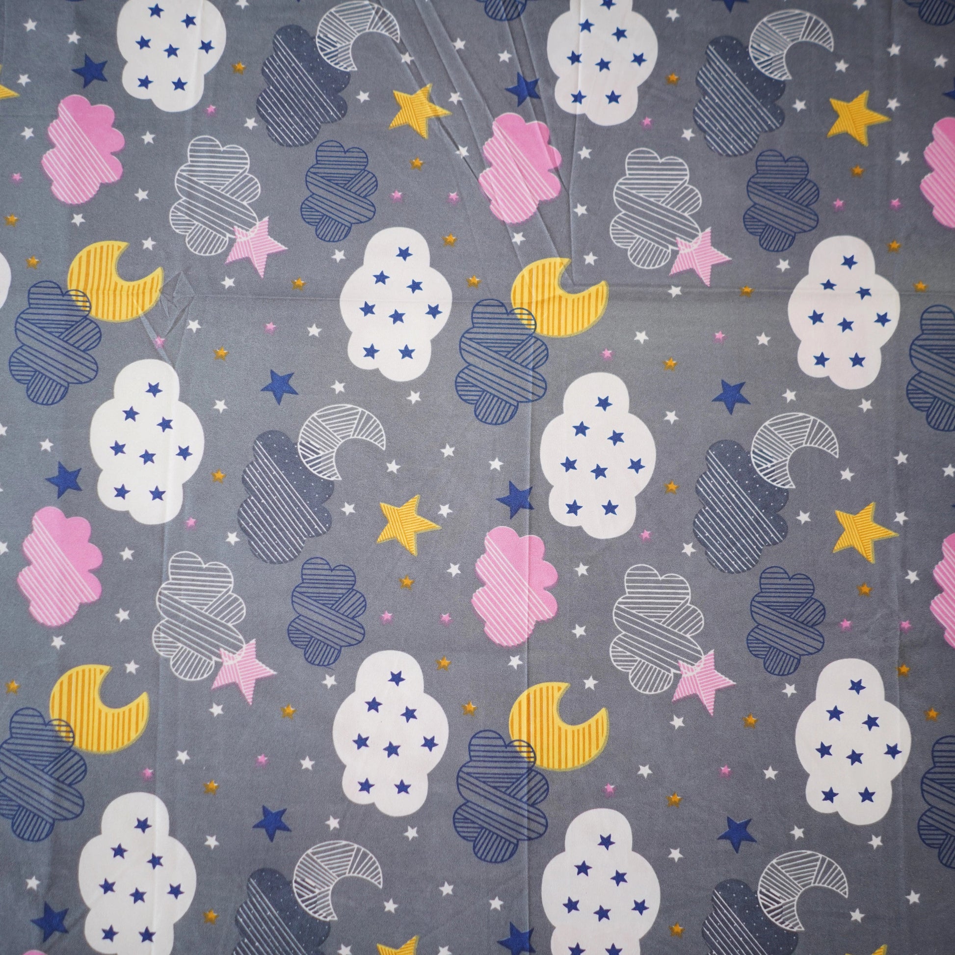 Patterned fabric with clouds, stars, and moons on a gray background
