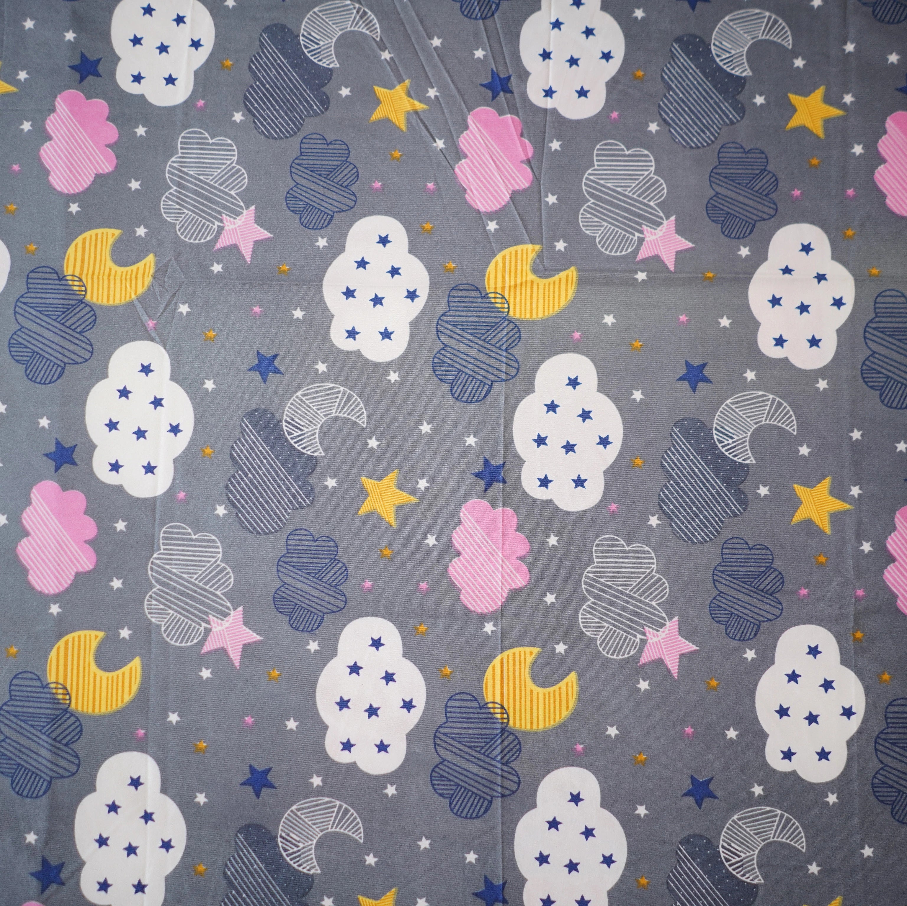 Patterned fabric with clouds, stars, and moons on a gray background