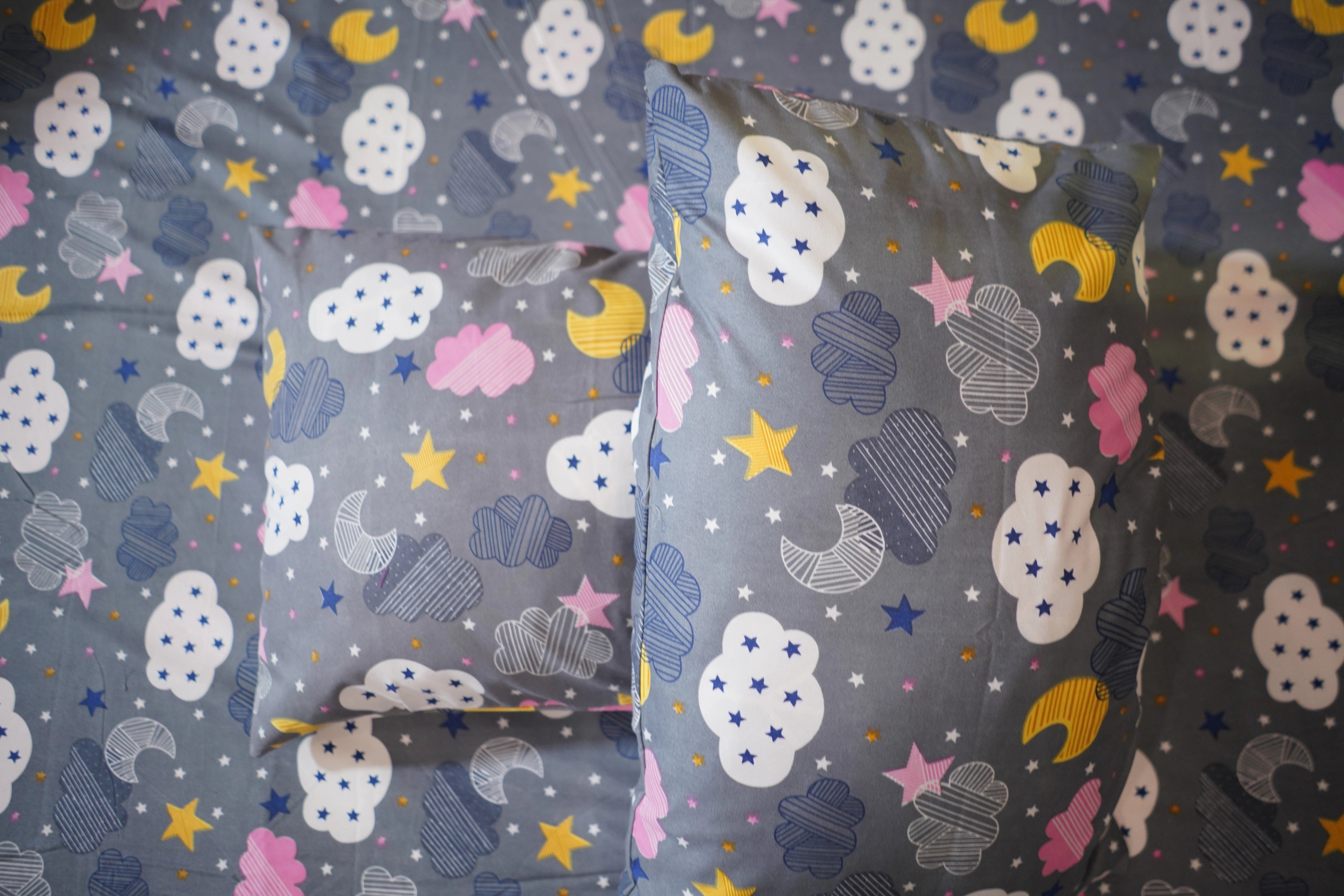 Children's bedding set with cloud, moon, and star pattern on gray background