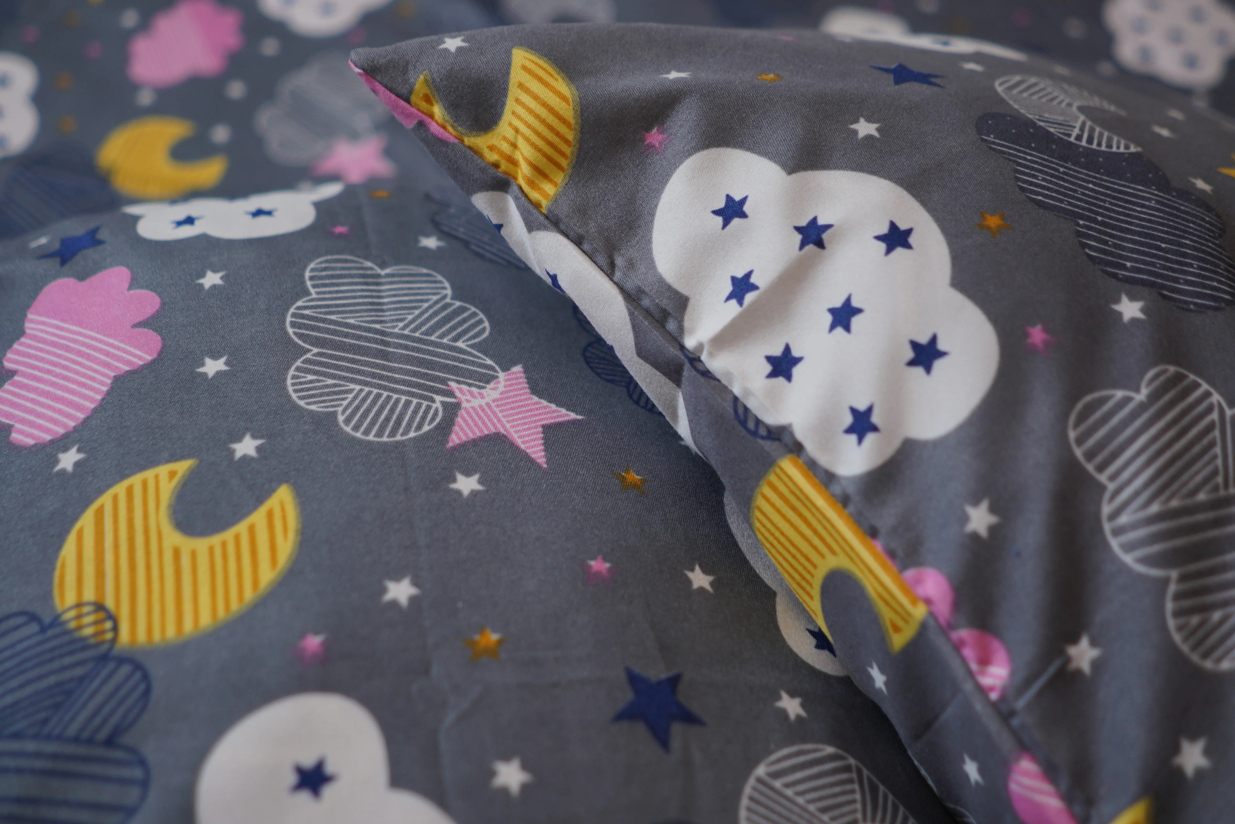 Fabric with cloud, moon, and star patterns on a gray background