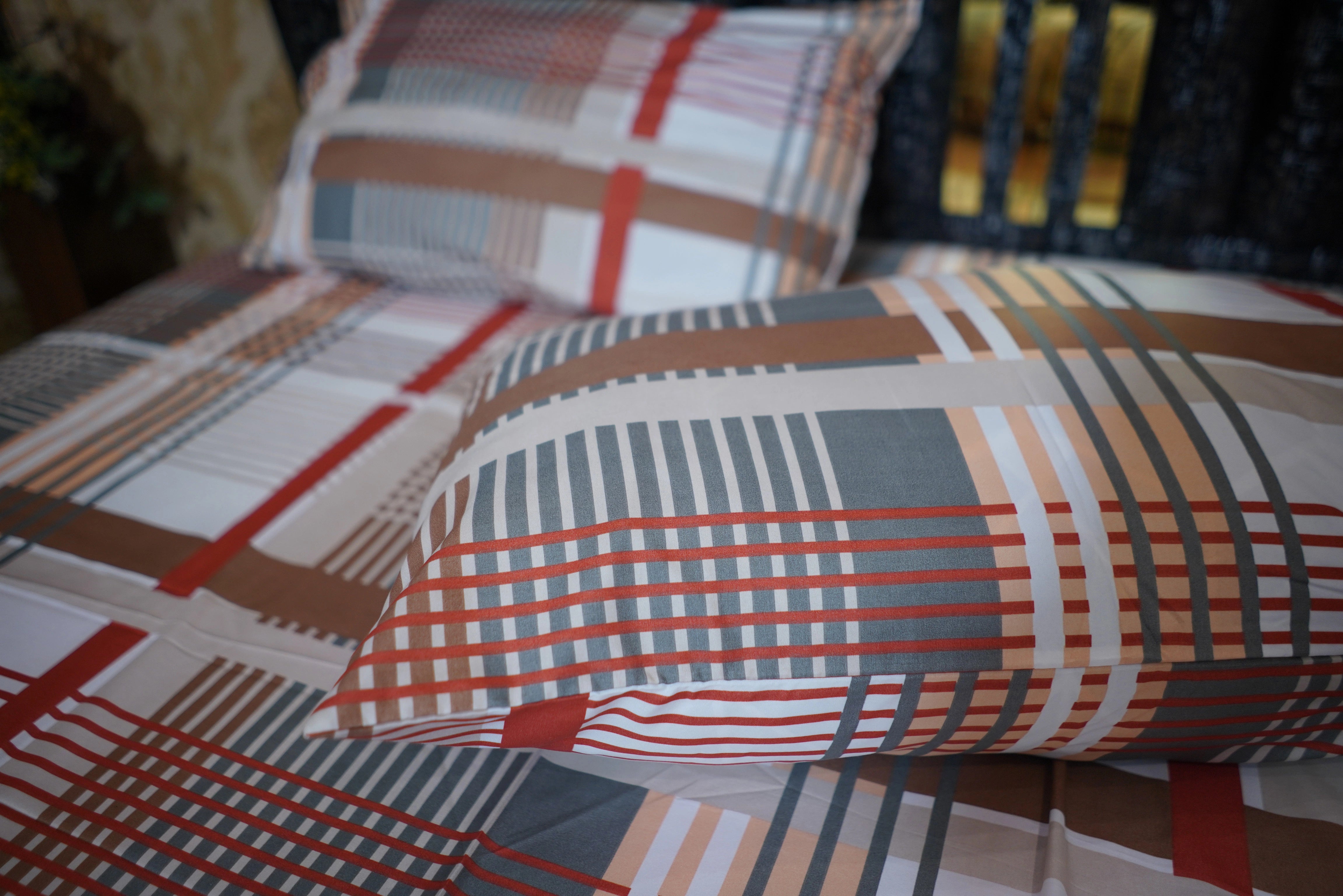 Plaid patterned pillows on a sofa with a blurred background