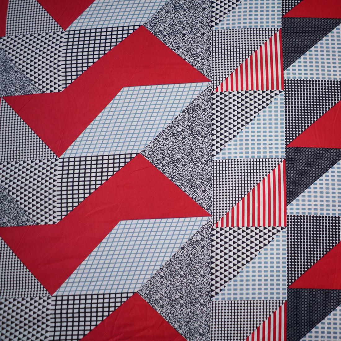 Geometric patterned quilt set on a bed in a bedroom setting