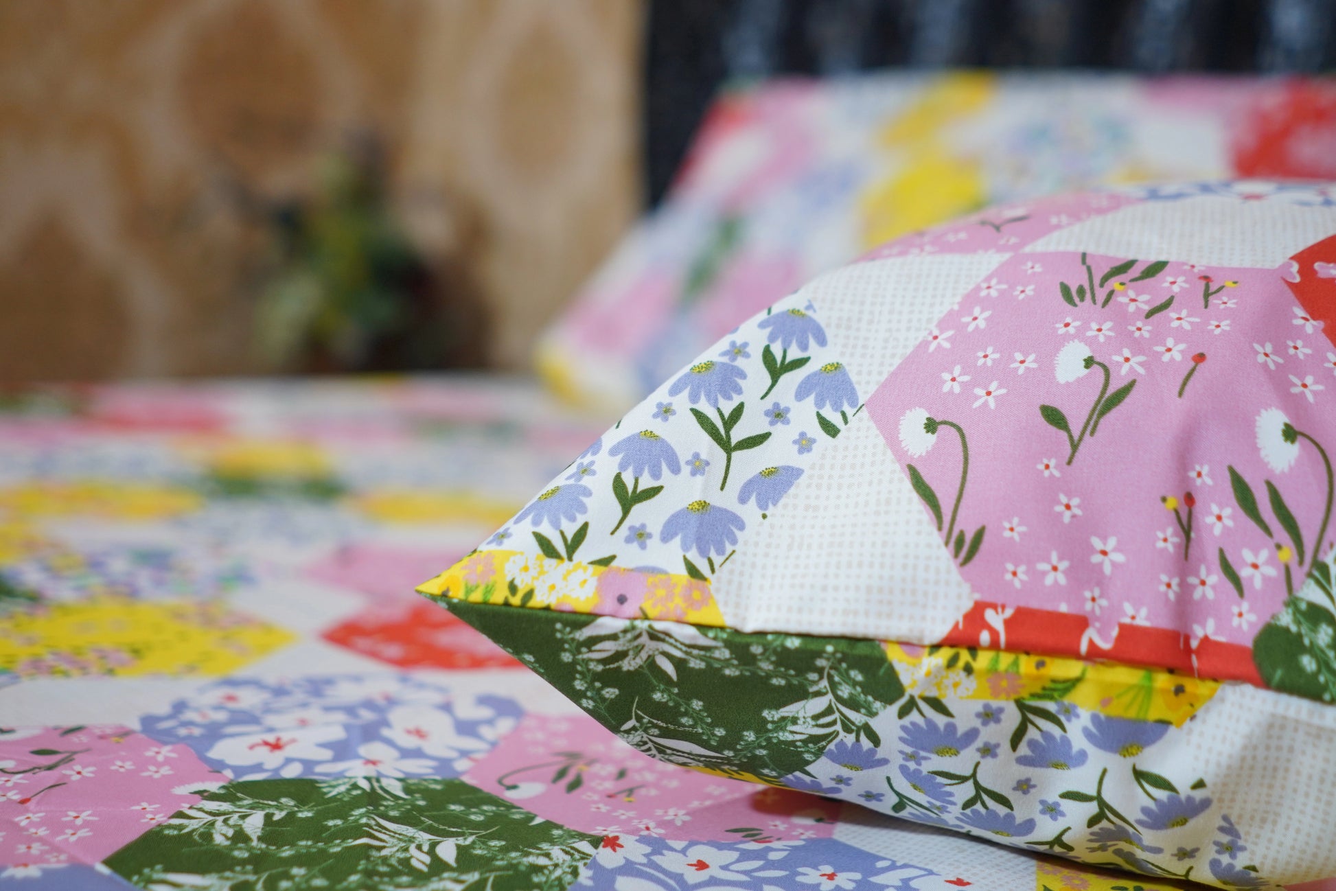 Close-up of a colorful patchwork quilt with floral patterns.