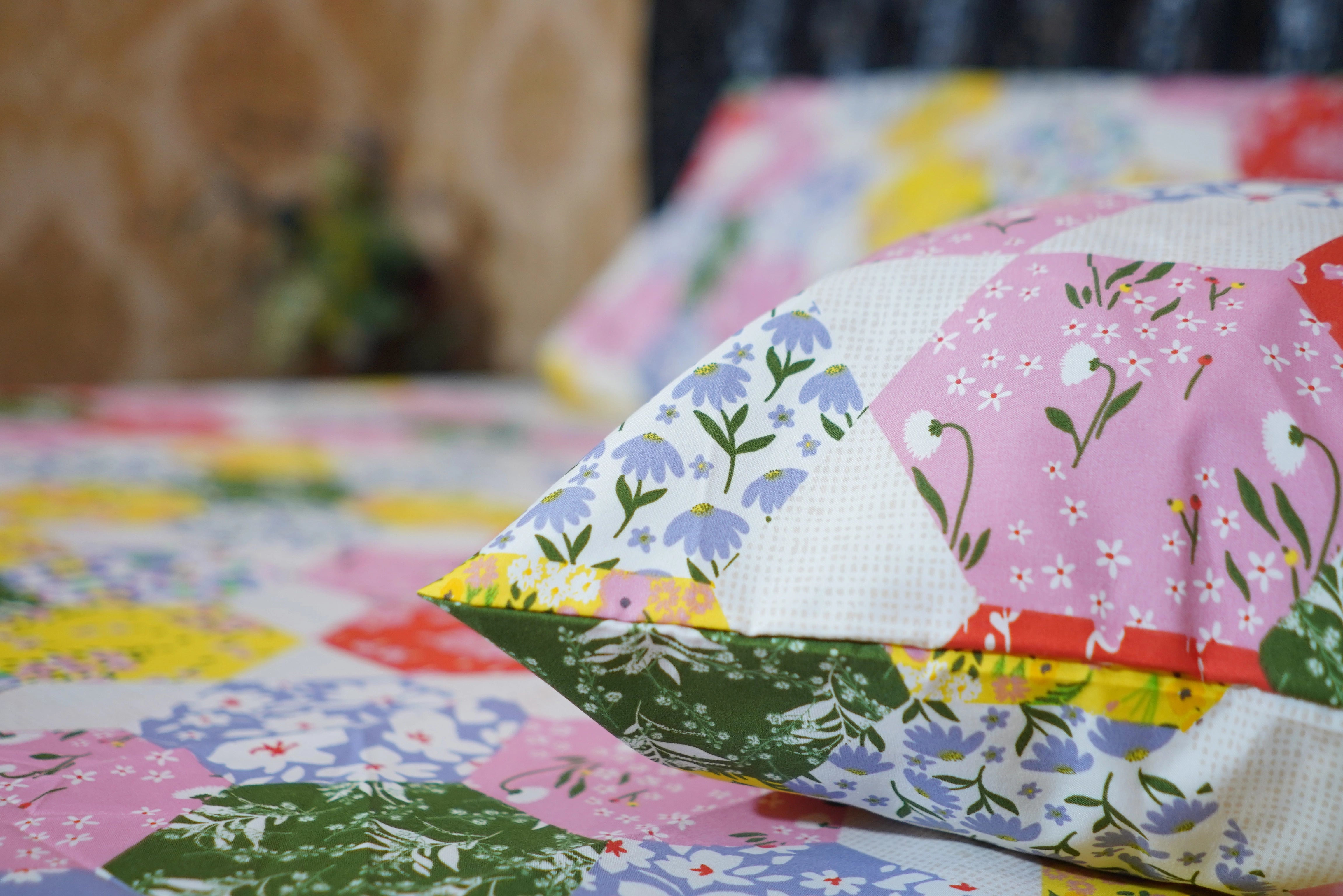 Close-up of a colorful patchwork quilt with floral patterns.