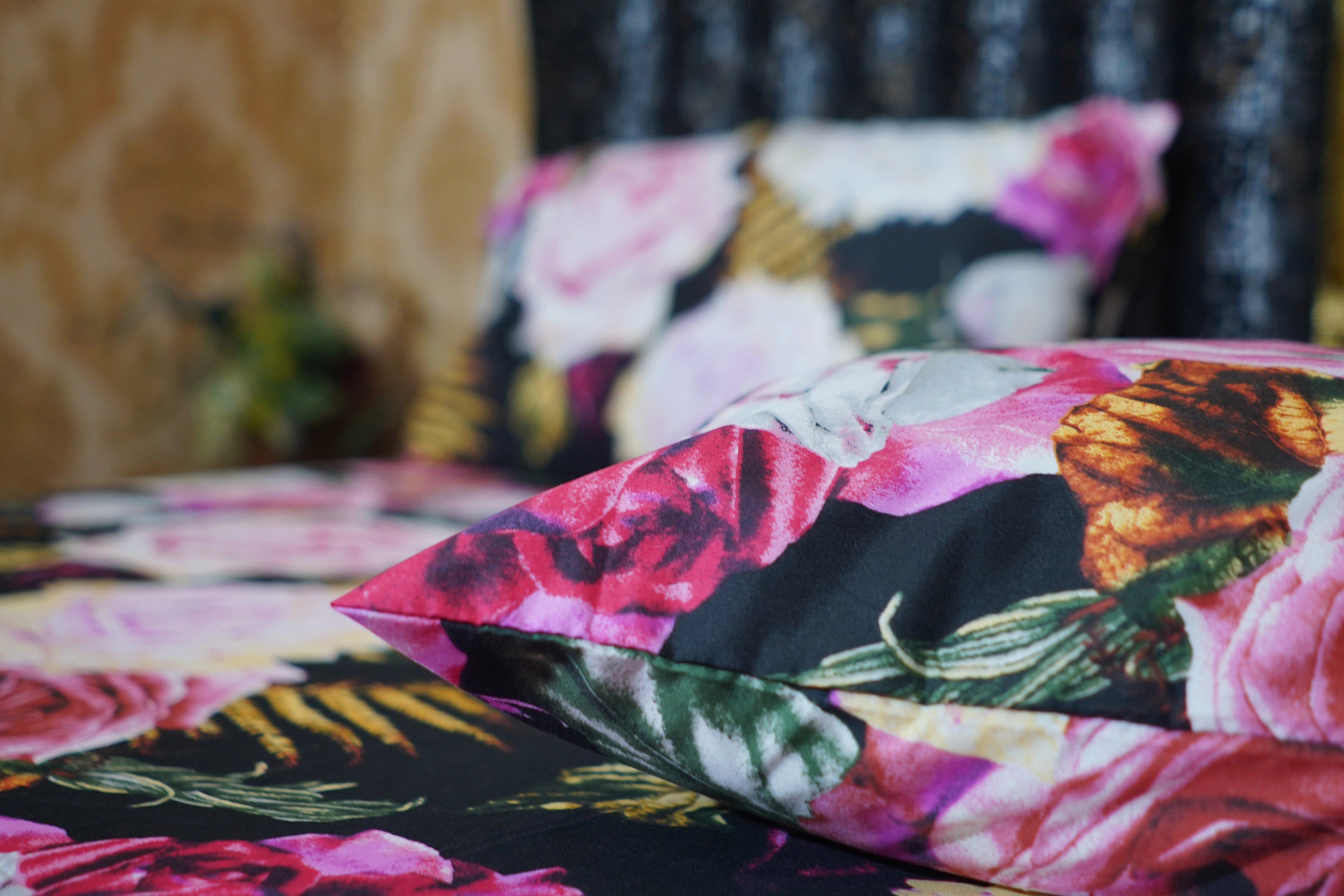 Floral patterned pillows on a bed with a blurred background