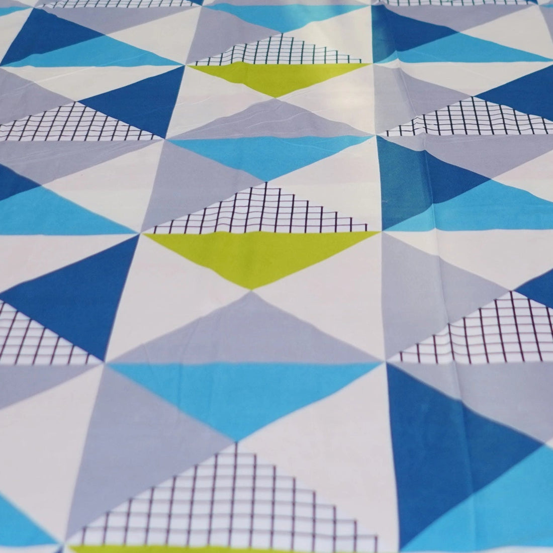 Geometric patterned bedding set on a bed with matching pillows and nightstands.