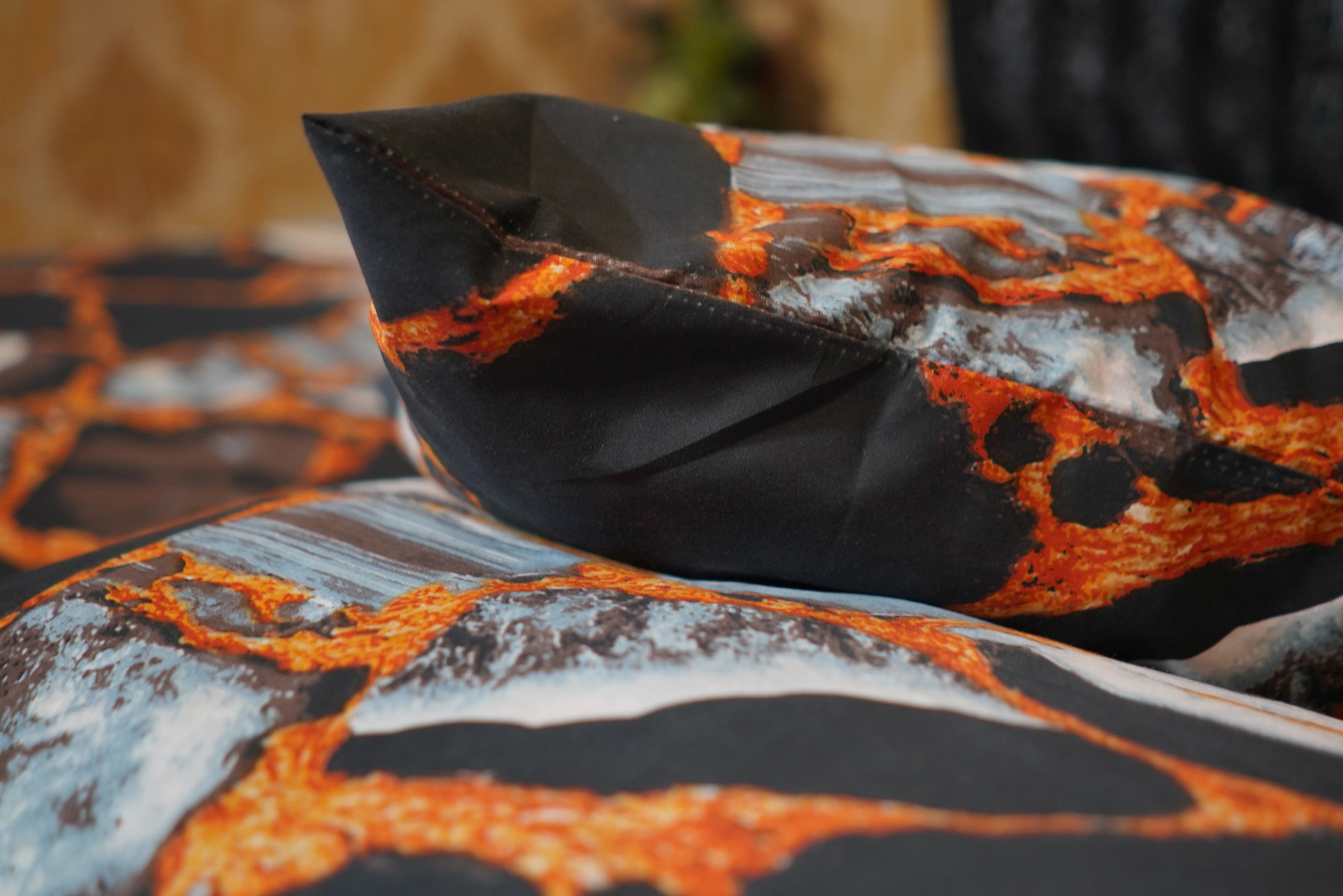 Close-up of a fabric with lava-like pattern in orange, black, and gray.