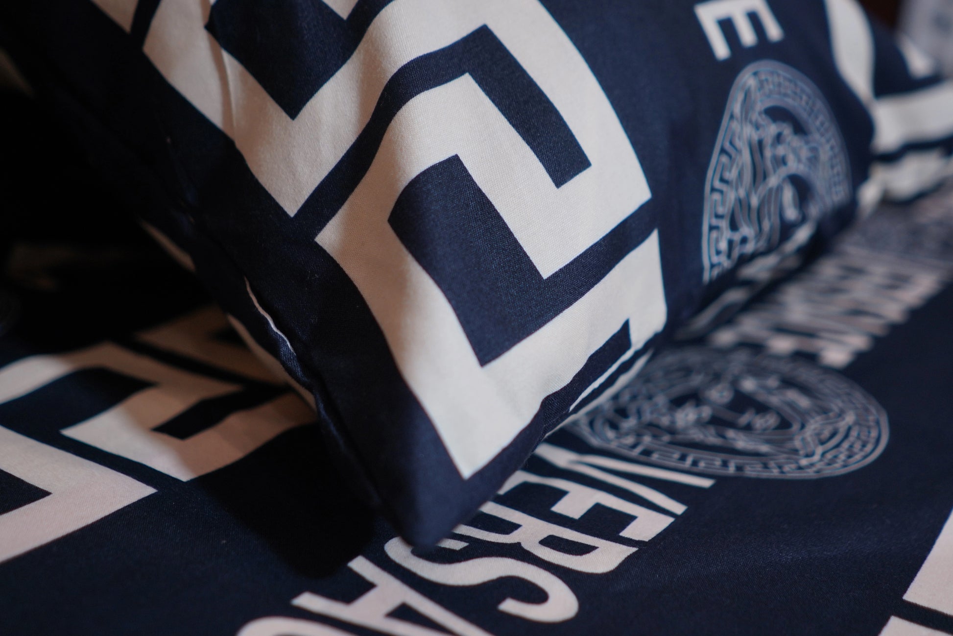 Close-up of a navy blue and white patterned fabric with visible branding.