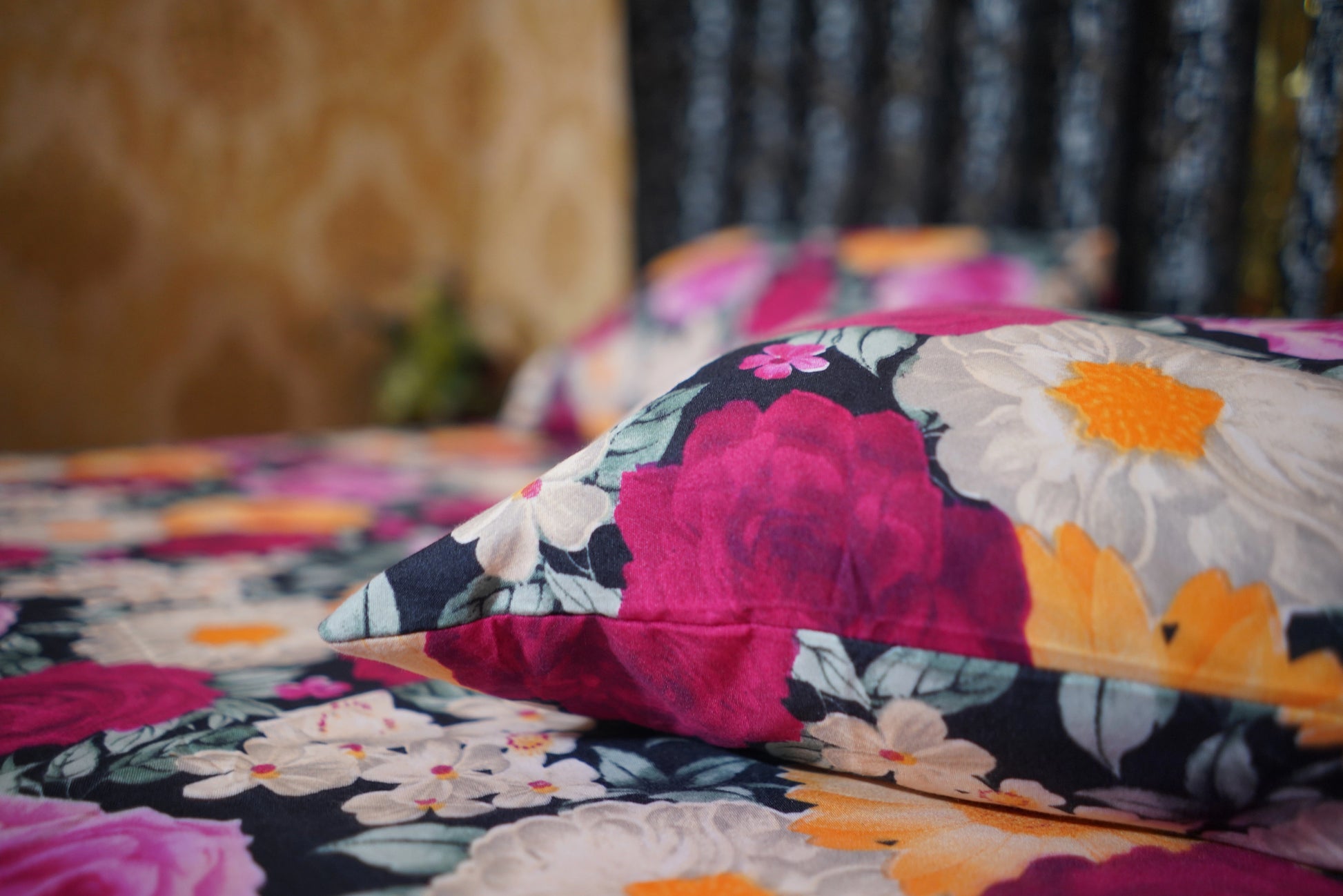 Floral patterned pillow on a bed with a blurred background