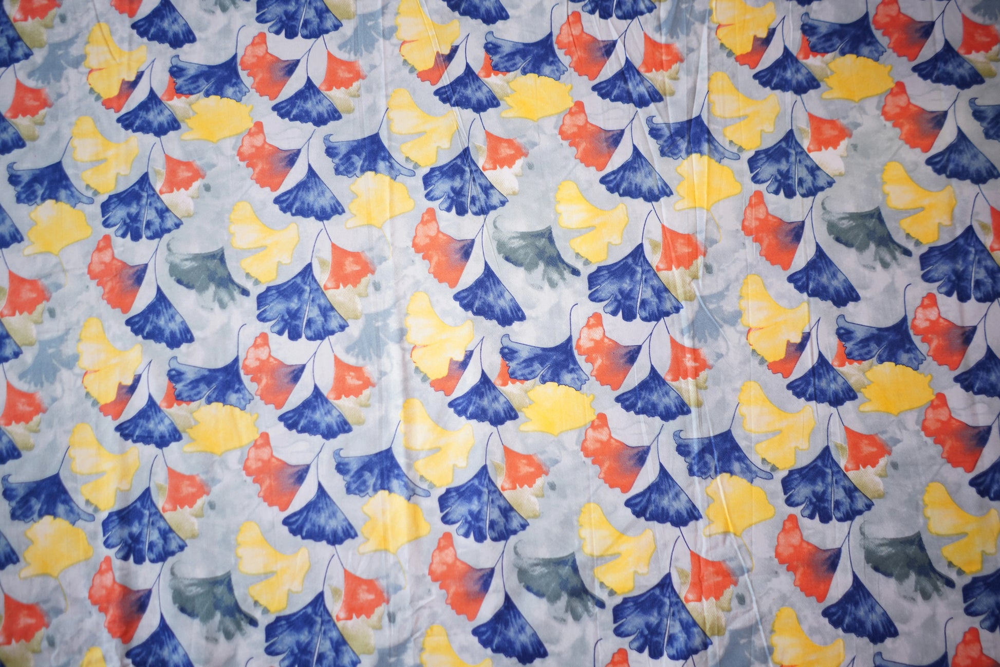 Patterned fabric with blue, yellow, and red flowers on a light background