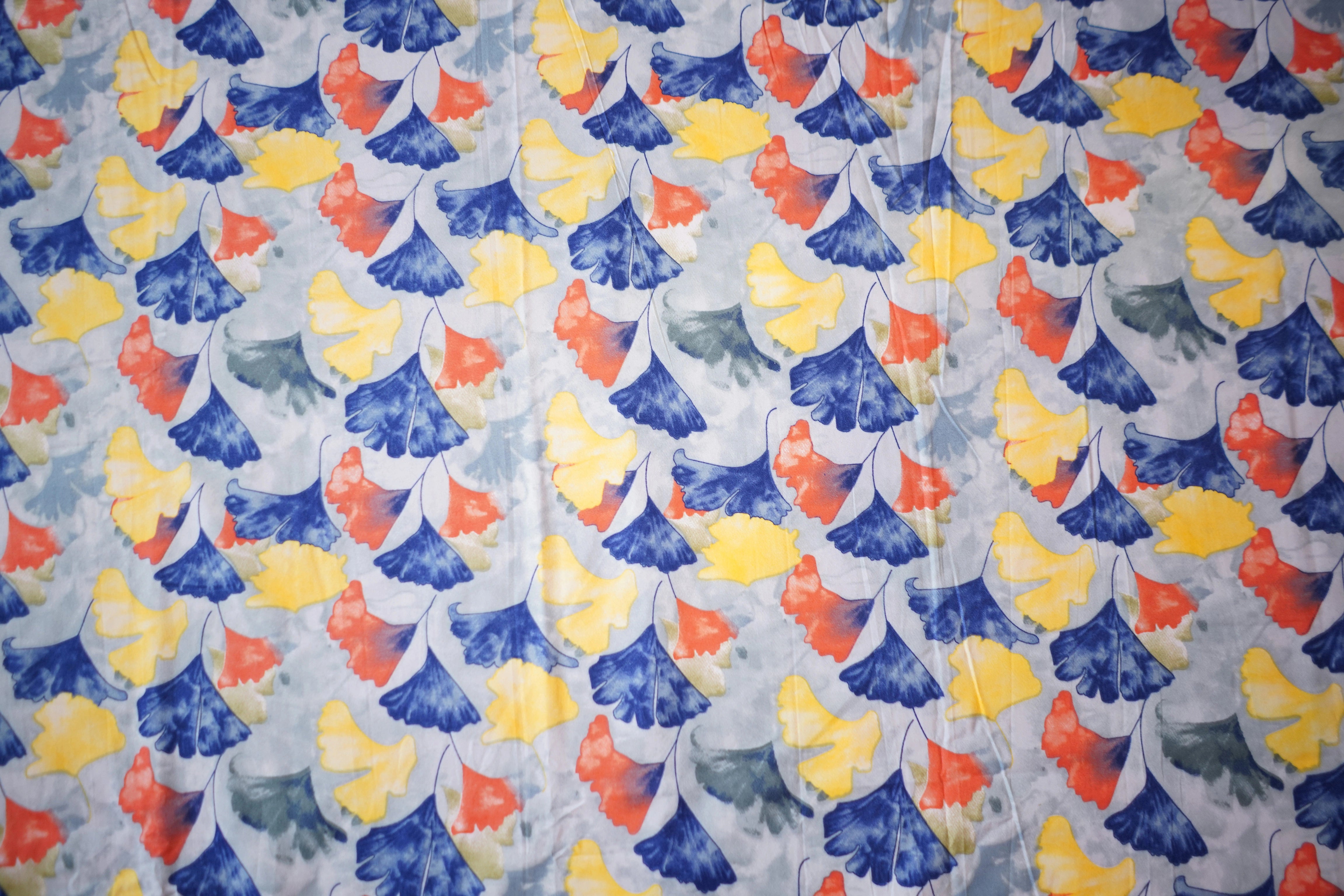Patterned fabric with blue, yellow, and red flowers on a light background