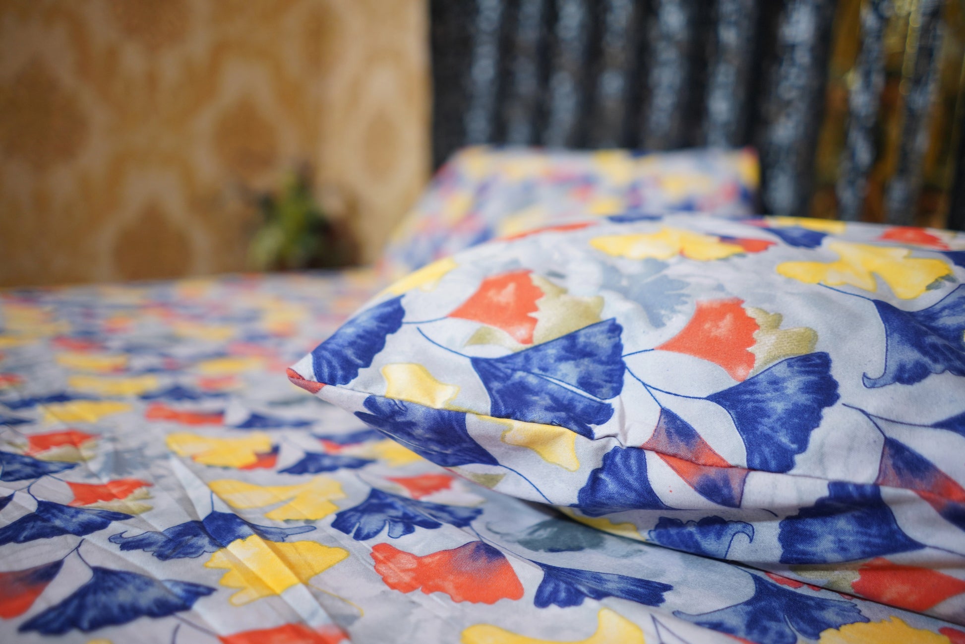 Colorful butterfly-patterned quilt on a bed with a blurred background