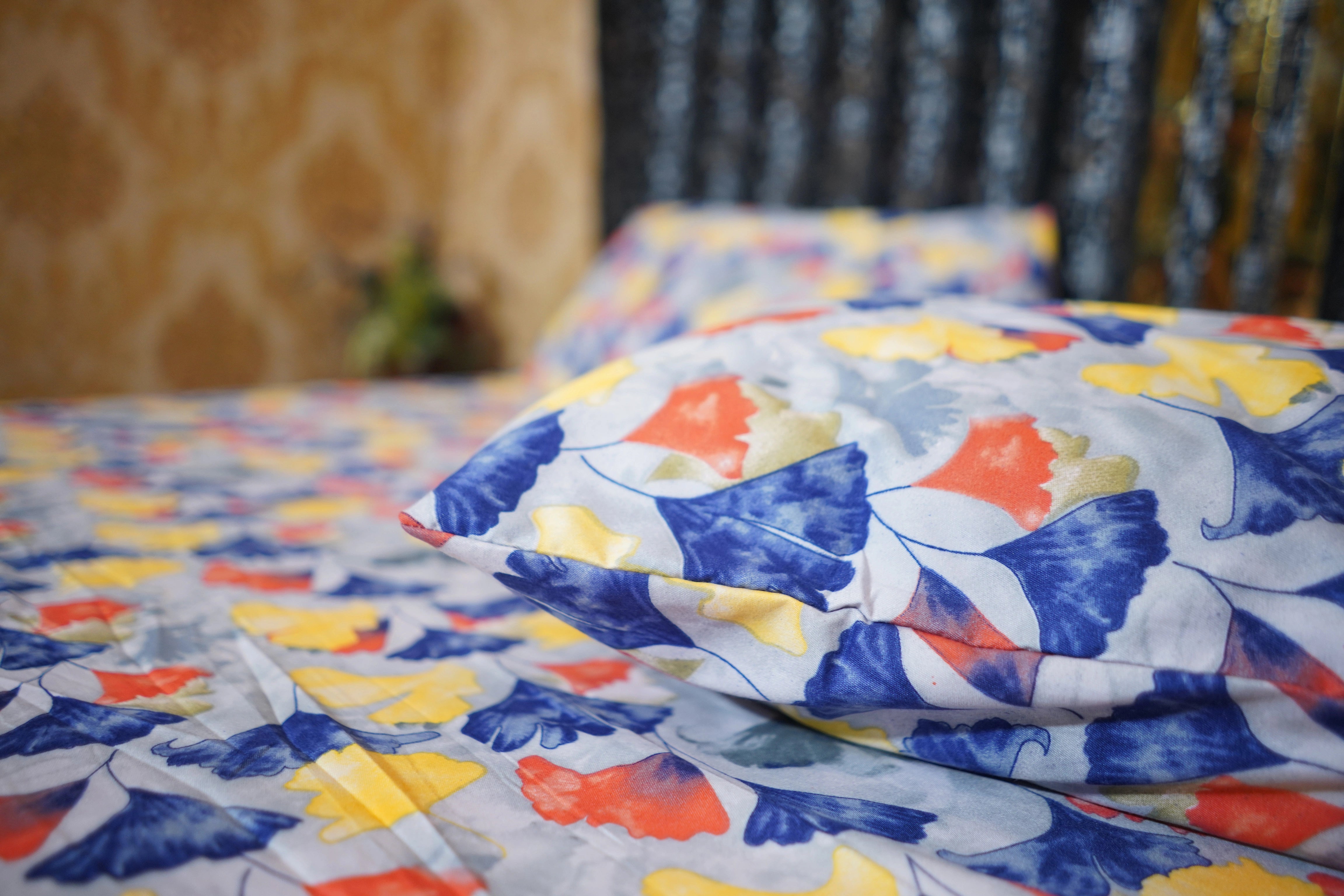Colorful butterfly-patterned quilt on a bed with a blurred background