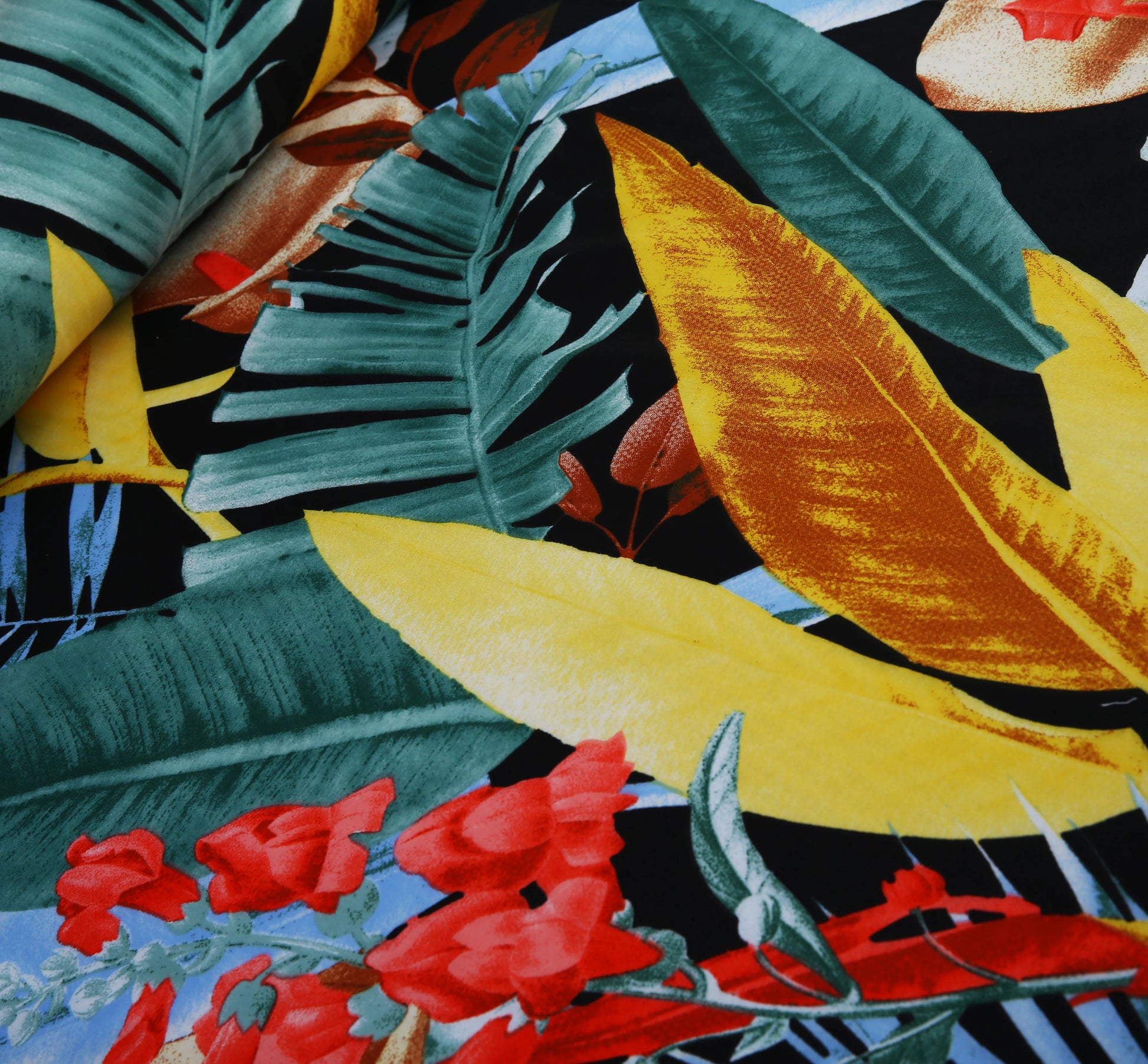 Colorful tropical leaf and flower pattern on a black background