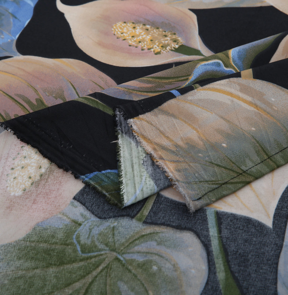 Close-up of a floral fabric swatch with pink flowers and green leaves.