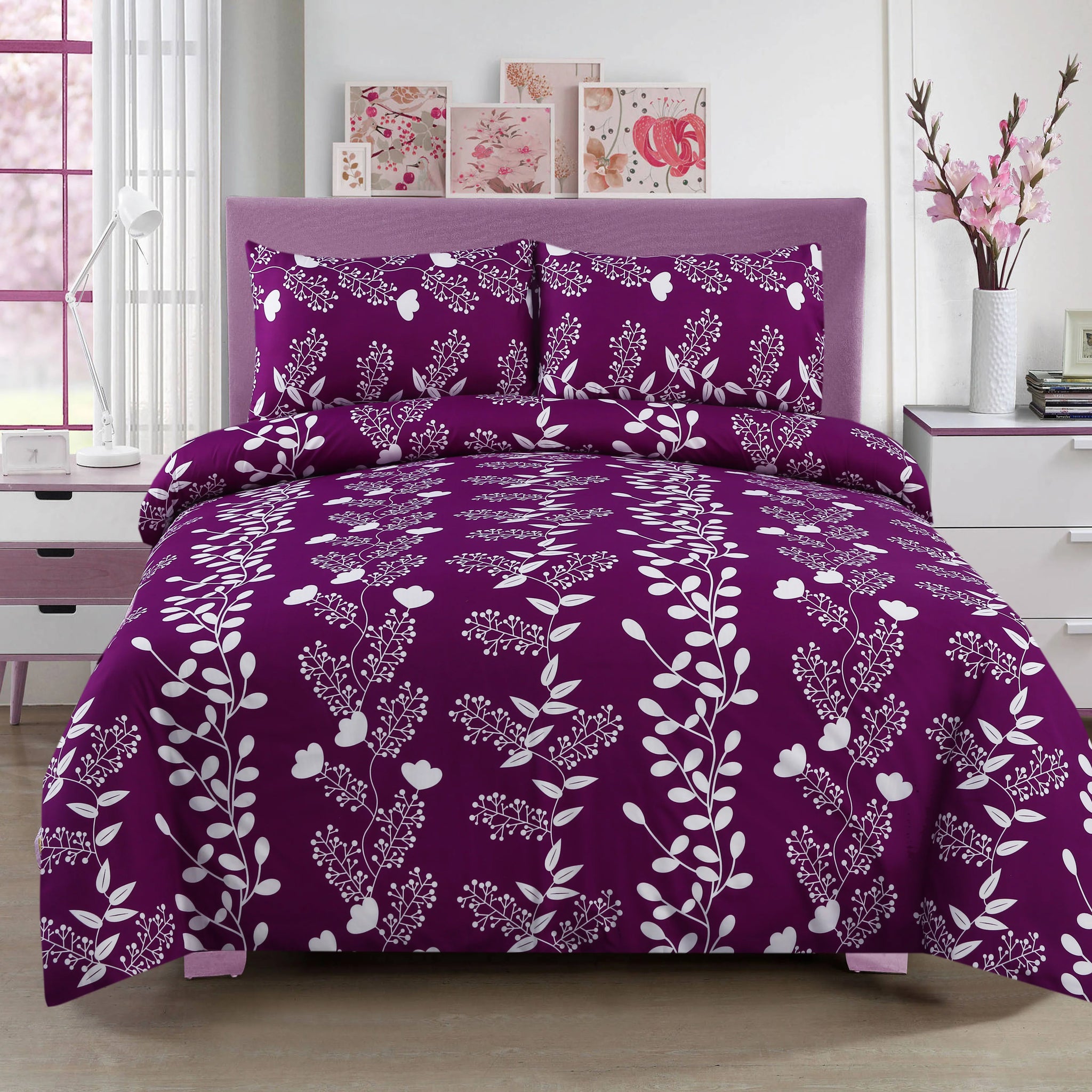 Purple floral bedding set on a bed in a bedroom with pink decor.