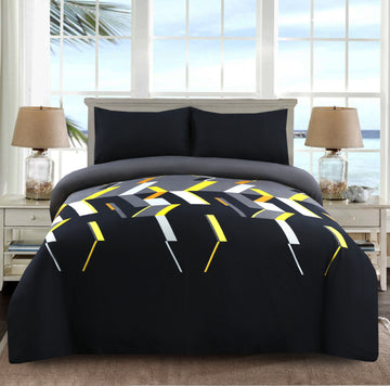 Bed with geometric patterned comforter in a room with large windows.