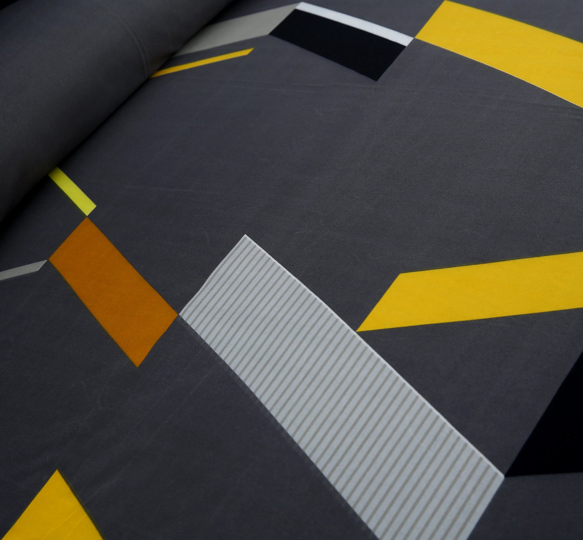 Close-up of a textured surface with geometric patterns in gray, yellow, and brown.