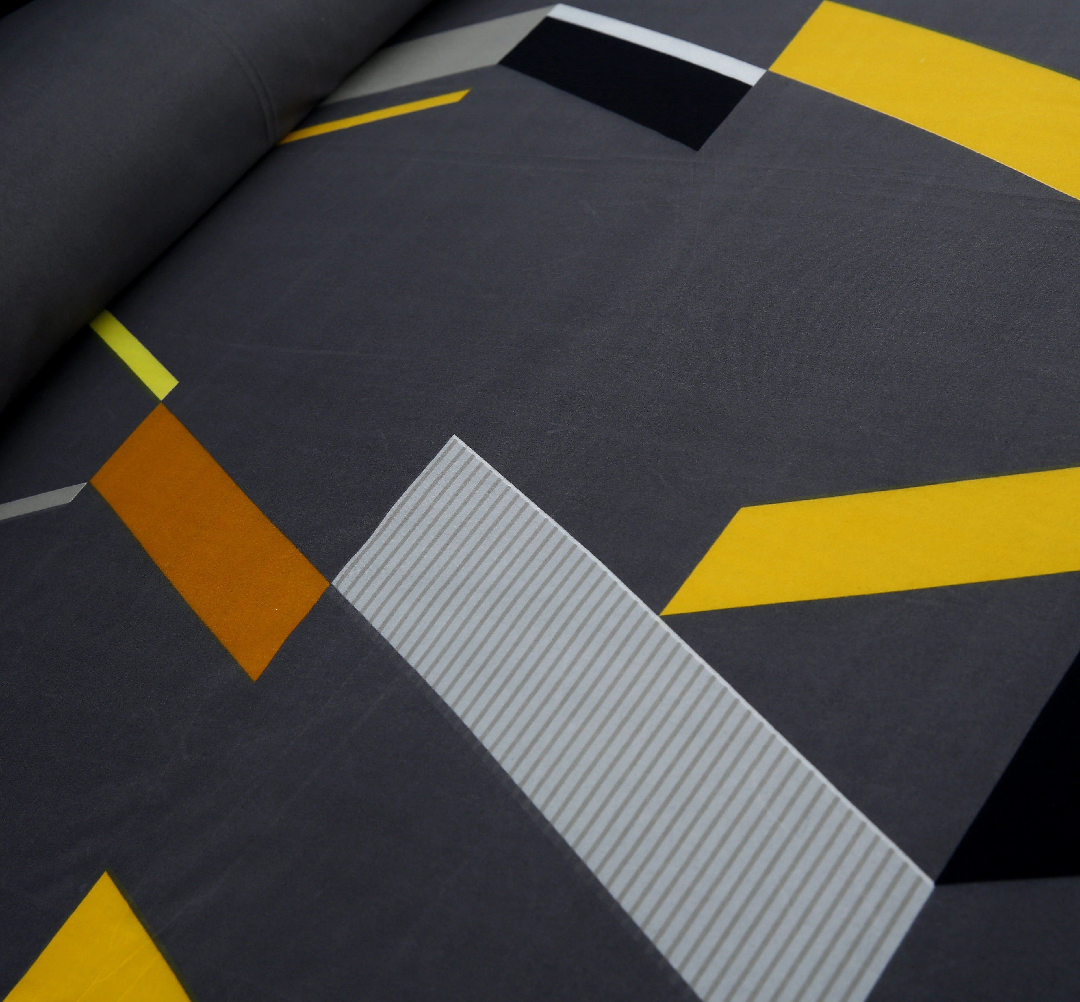 Close-up of a textured surface with geometric patterns in gray, yellow, and brown.