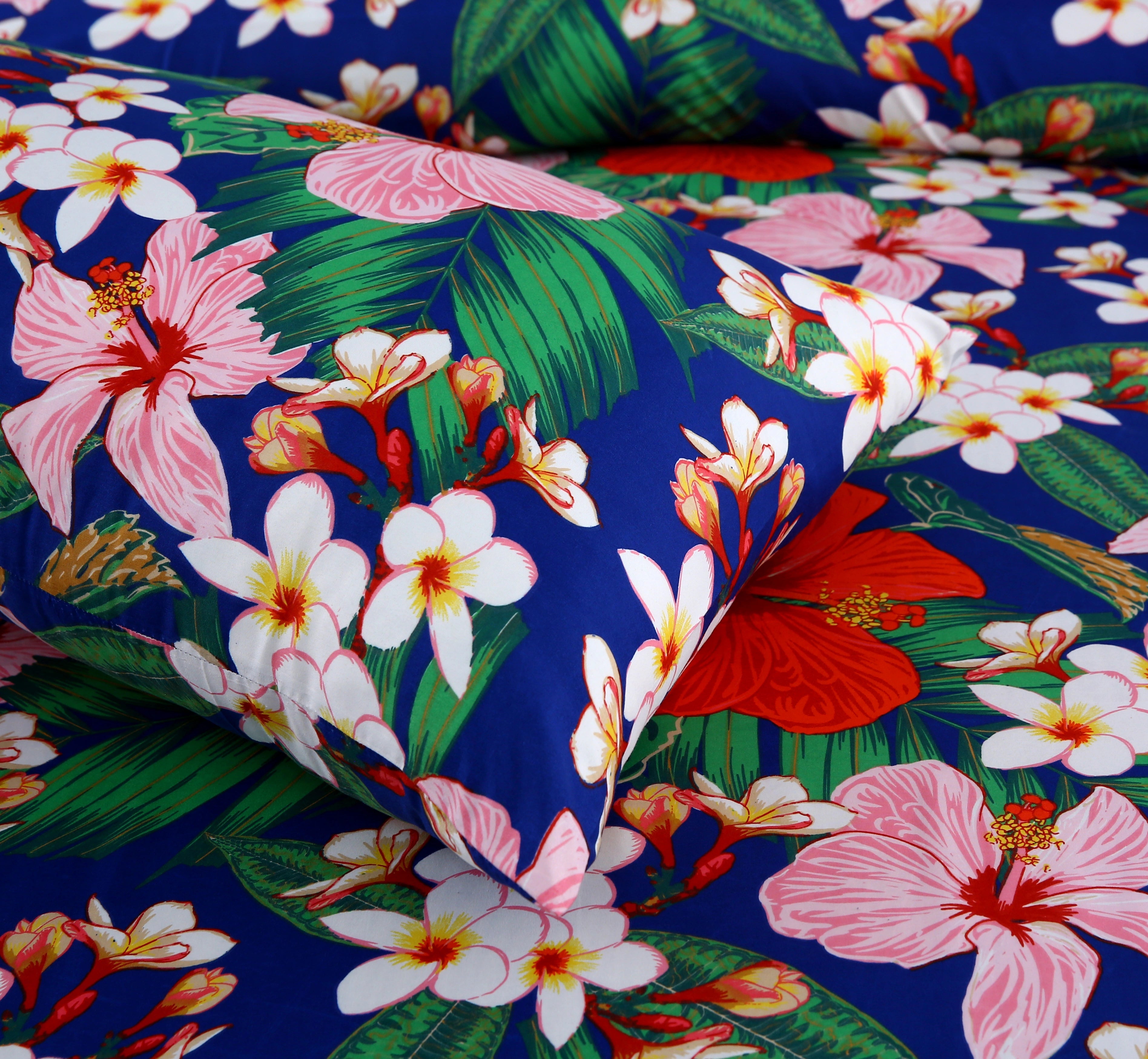 Tropical floral fabric with pink, white, and red flowers on a blue background