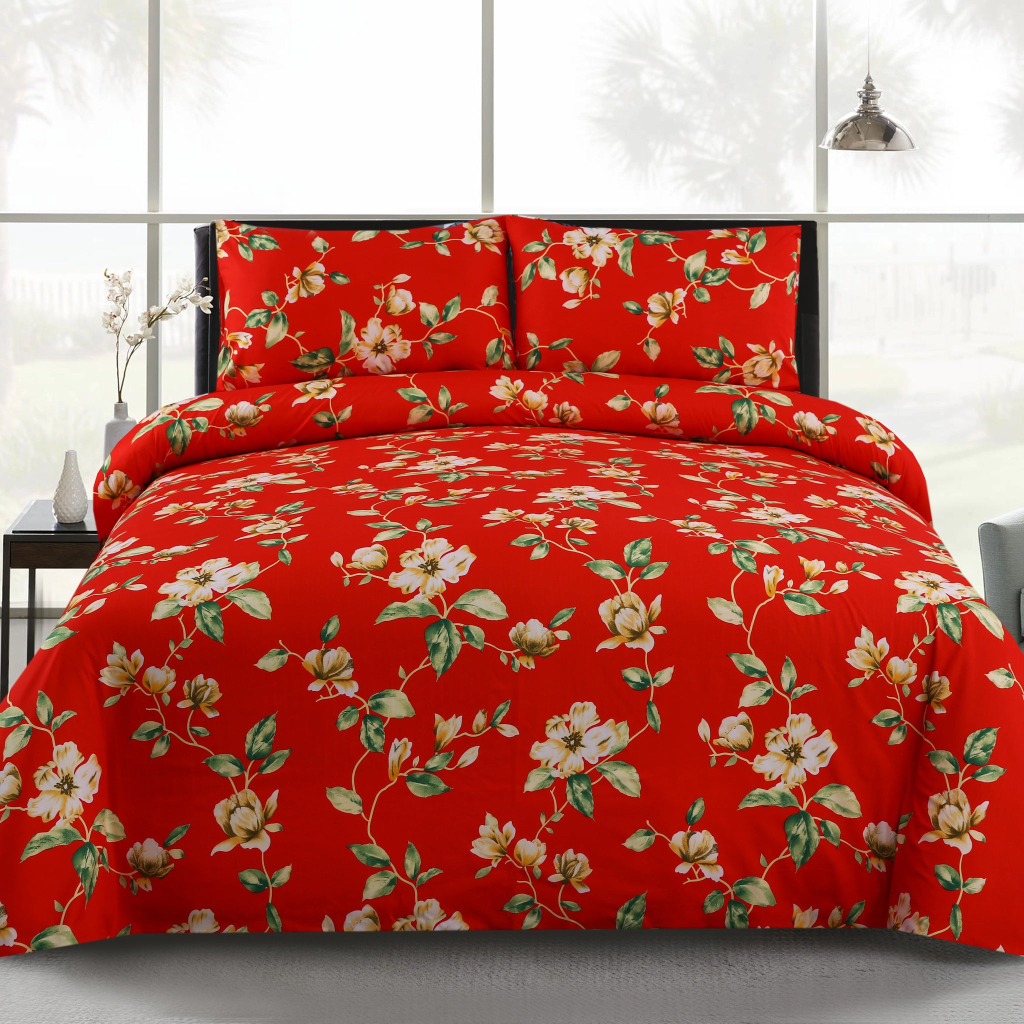 Red floral bedding set on a bed with a white background