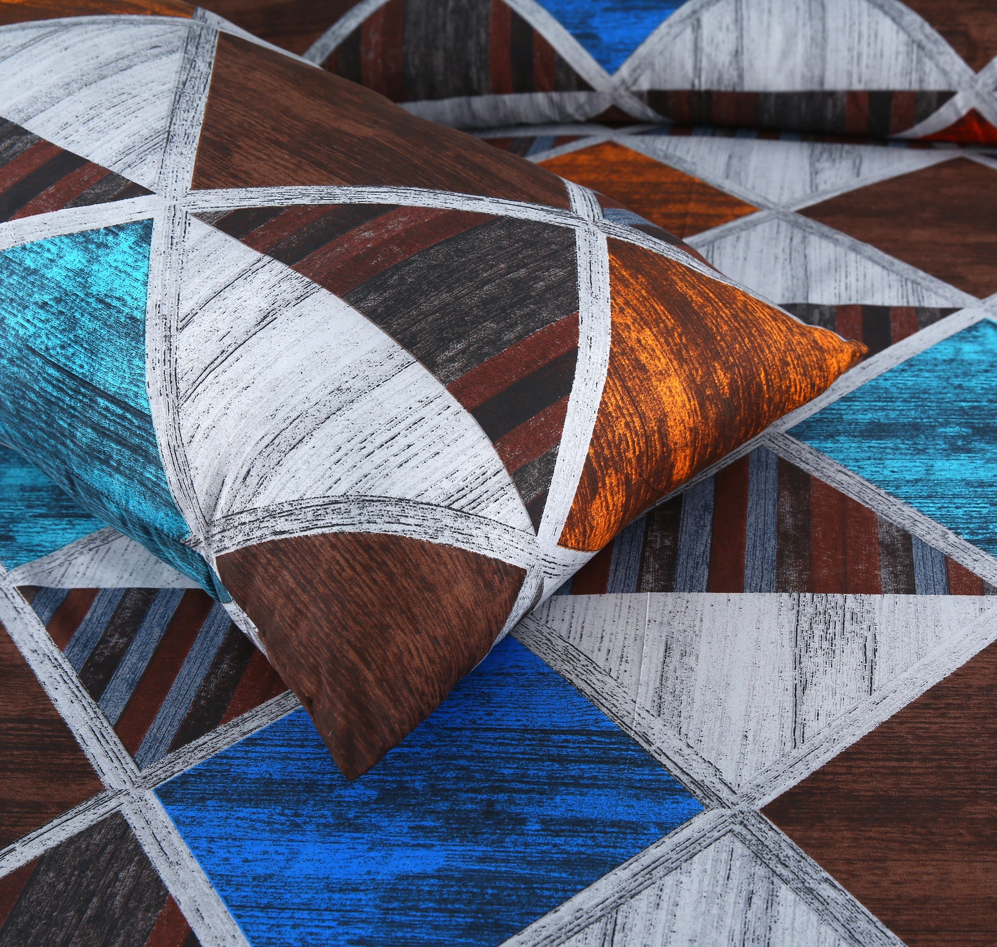Geometric patterned pillows in brown, blue, and gray on a matching fabric background