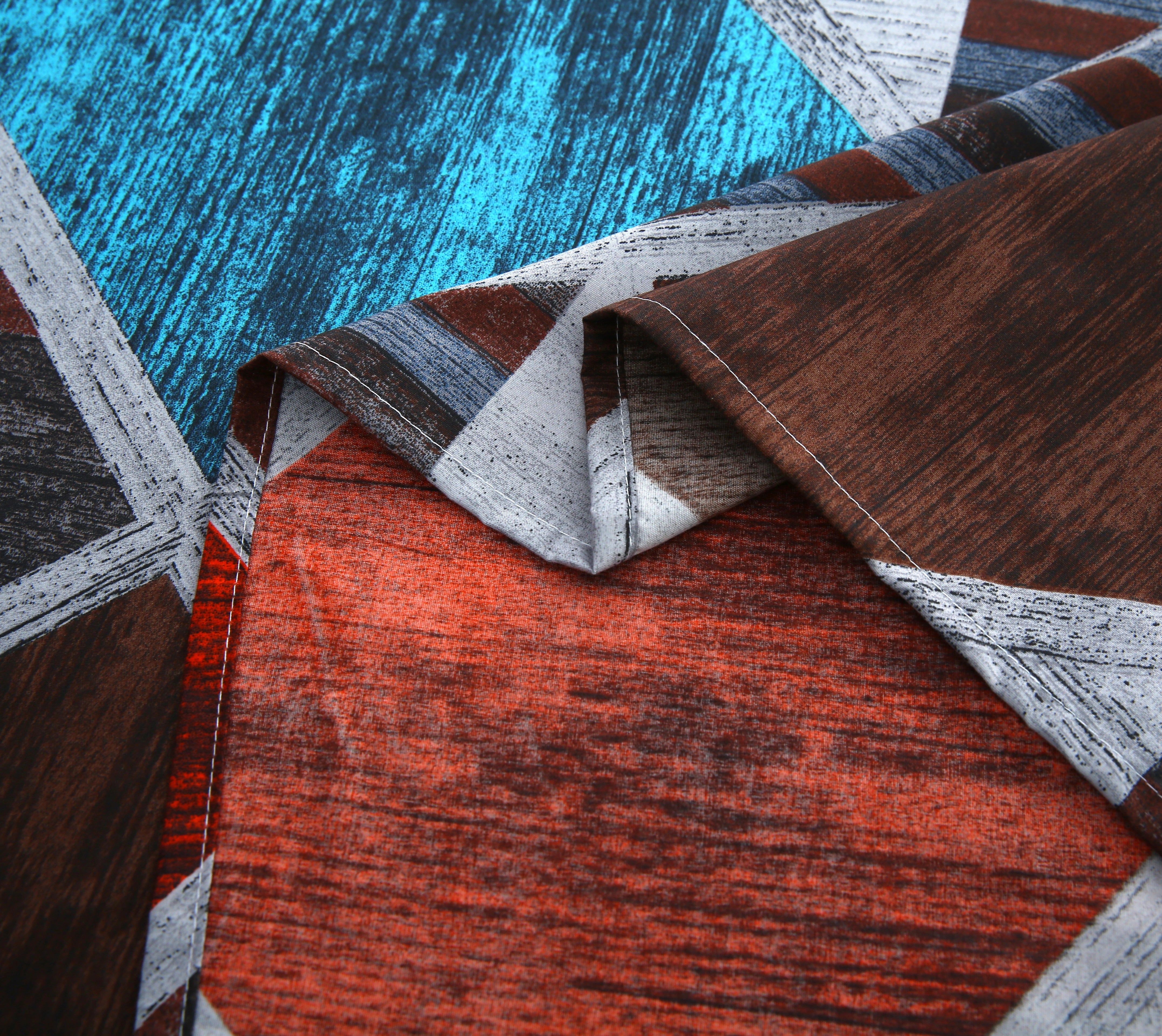 Close-up of a patterned fabric with geometric shapes in red, blue, and gray.