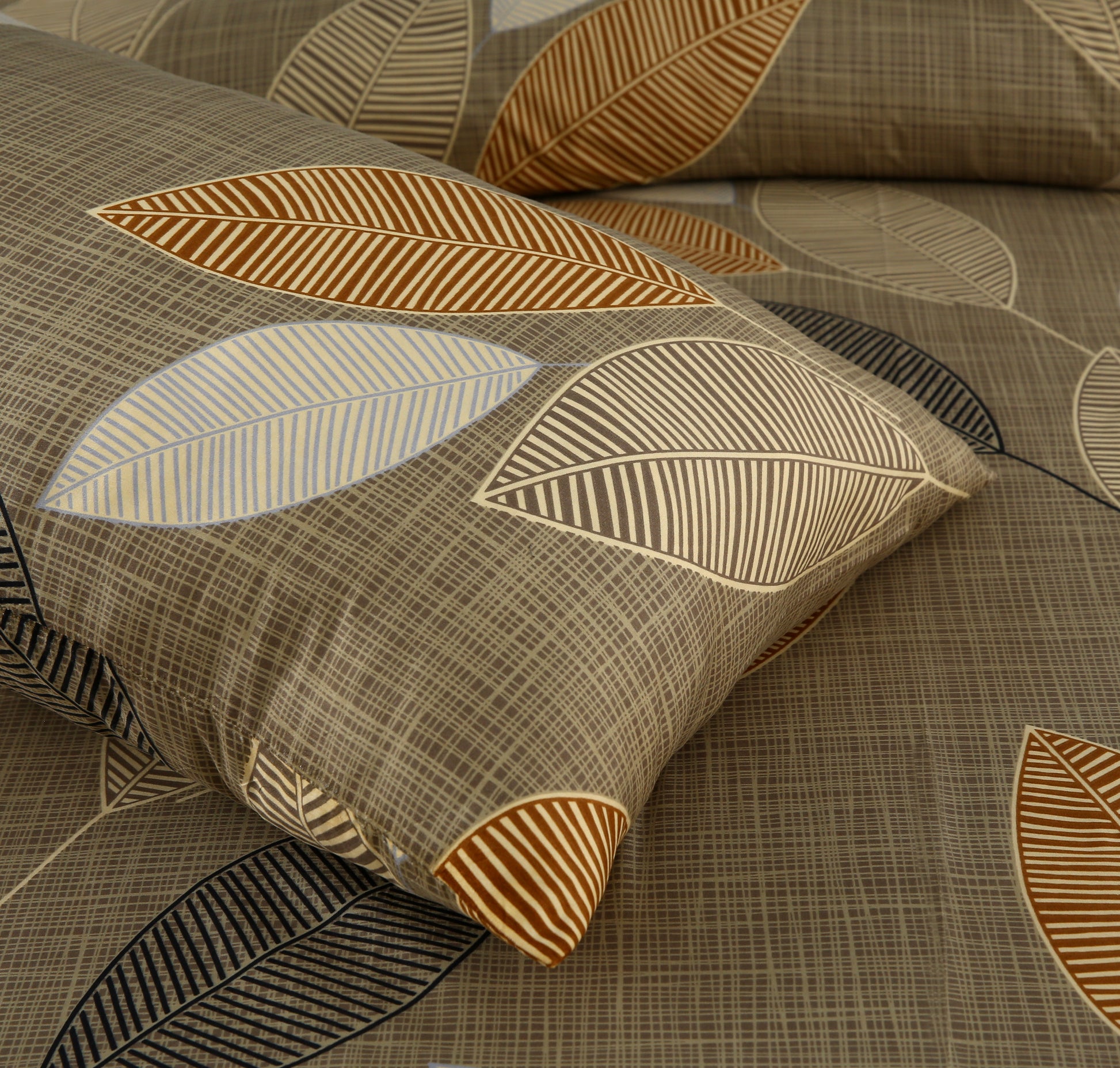 Decorative pillow with leaf pattern on a textured fabric background