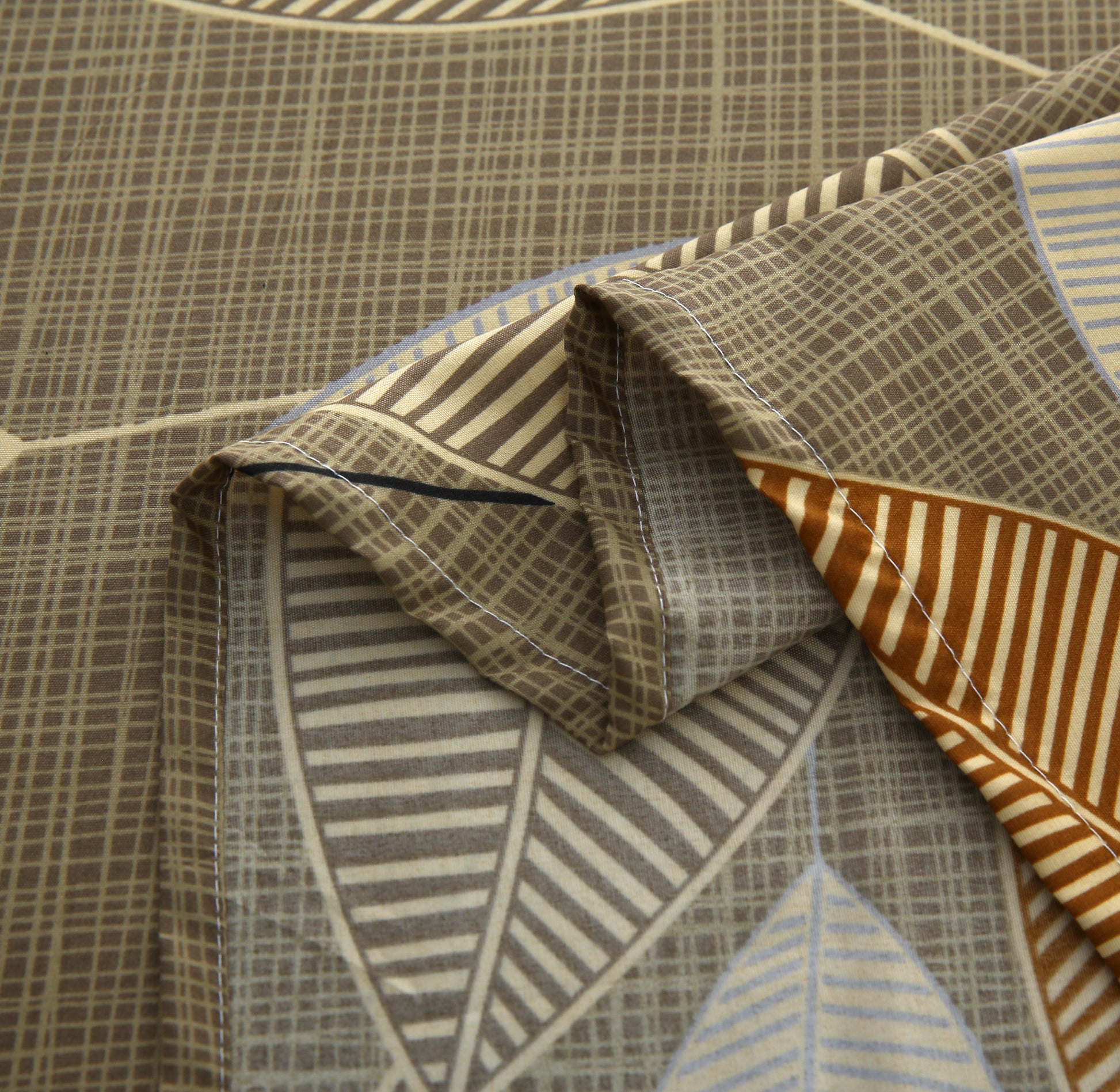 Close-up of patterned fabric with geometric designs in brown, blue, and orange.