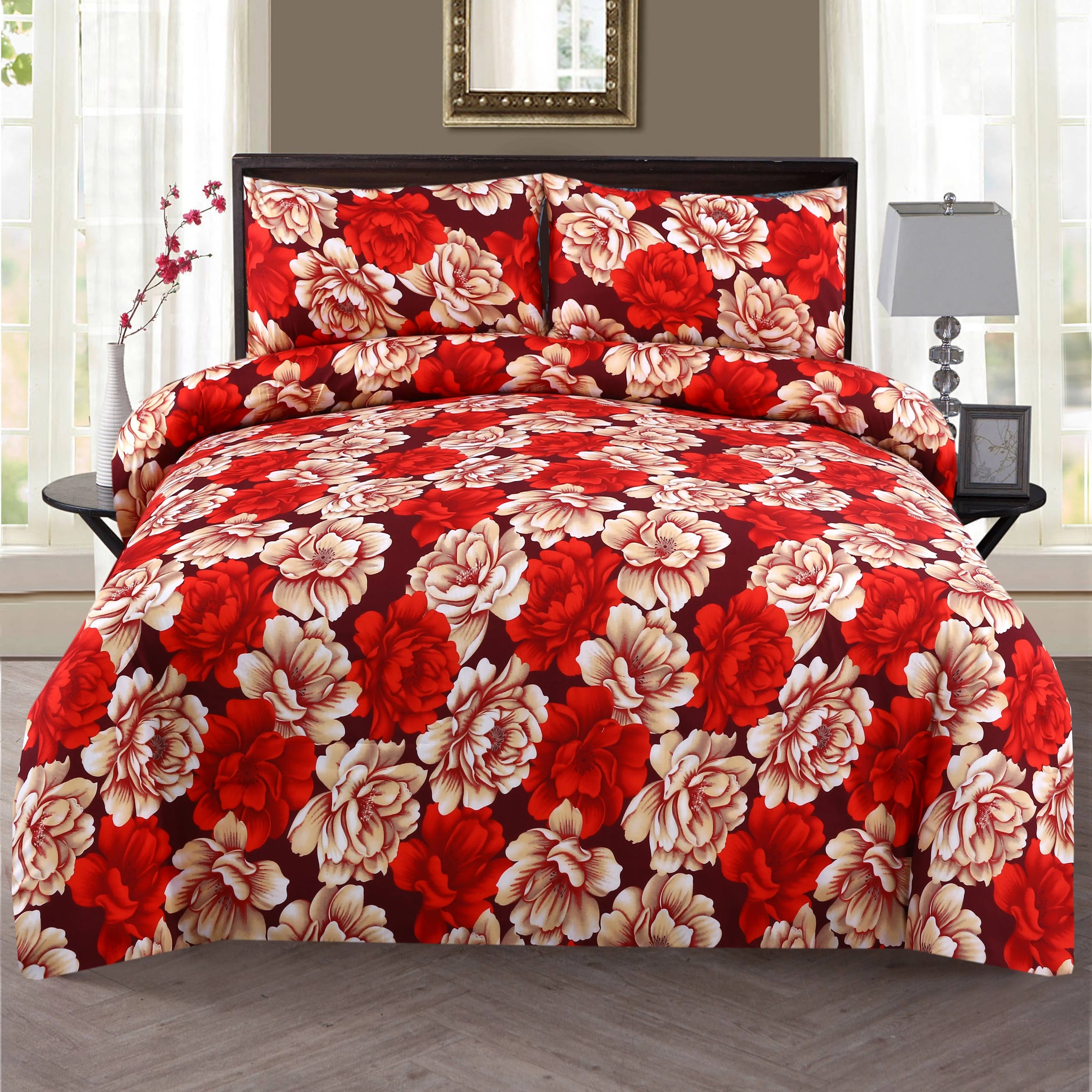 Floral bedding set with red and beige flowers on a bed in a bedroom.