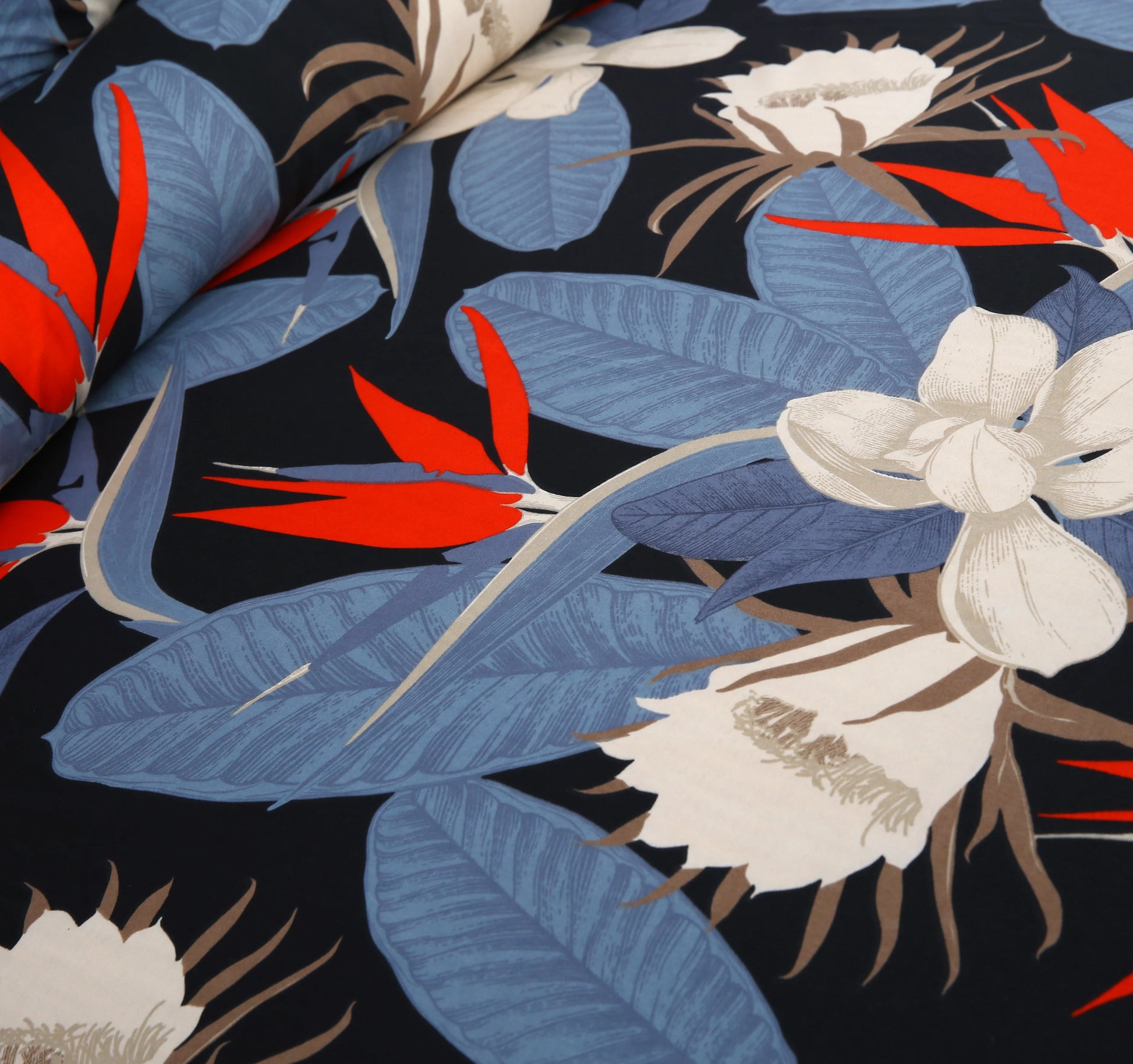 Tropical floral pattern with red, blue, and white flowers on a black background