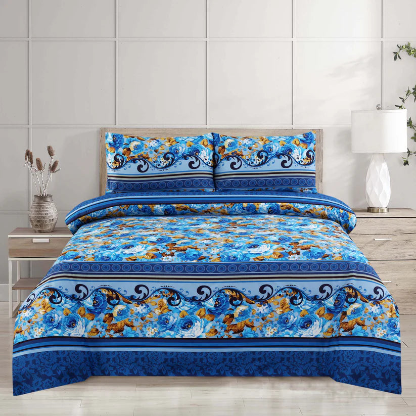 Blue floral patterned bedspread on a bed with matching pillows in a bedroom setting.