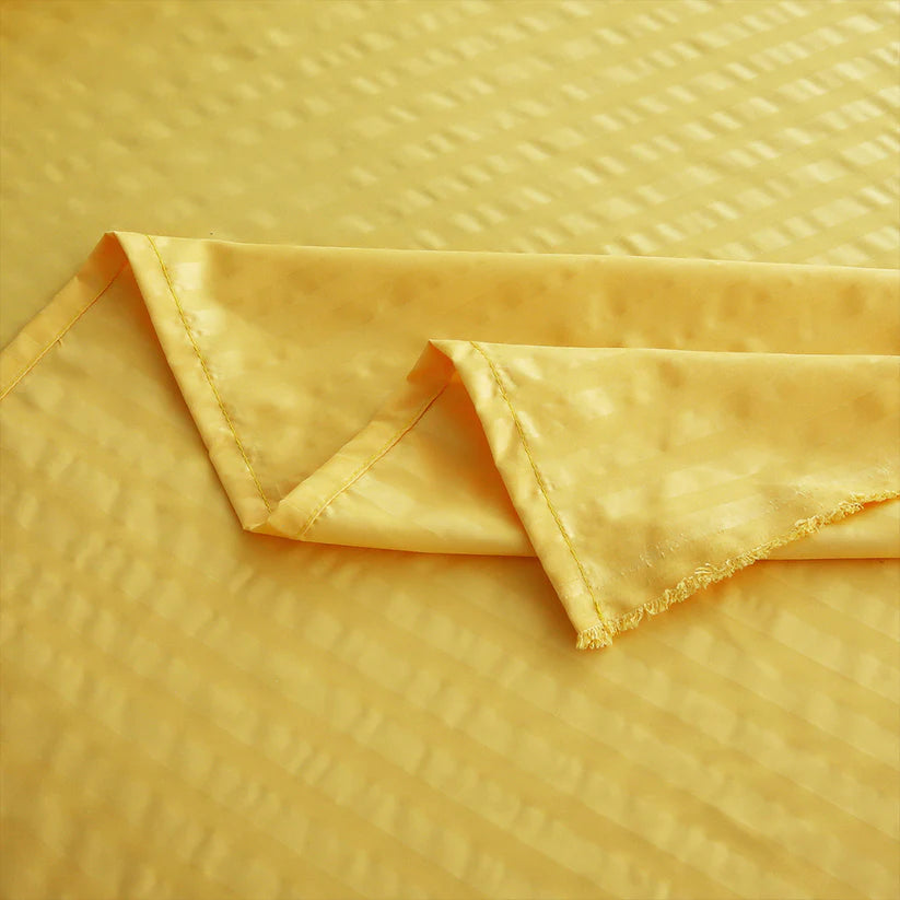 Folded yellow fabric on a textured yellow background