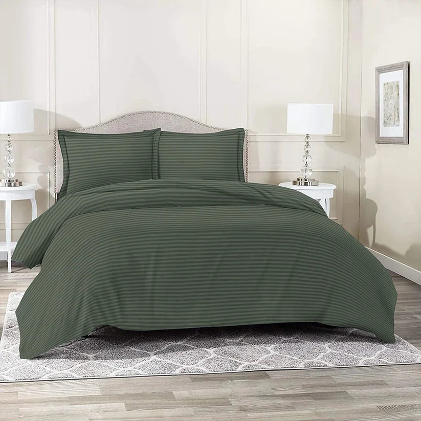 Green striped bedding set on a bed in a bedroom with nightstands and lamps.